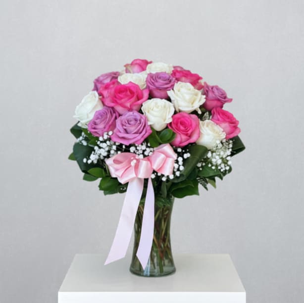 Mother's Day Rosey Day (2 Dozen) - MOTHER'S DAY COLLECTION | LOCAL DELIVERY ONLY  Timeless and full of love, "Mother's Day Rosey Day" features two dozen mixed-color roses arranged in a clear gathering vase with delicate touches of baby's breath and aspidistra leaves. Classic, graceful, and effortlessly beautiful - this bouquet is made for the mom who never goes out of style. 
