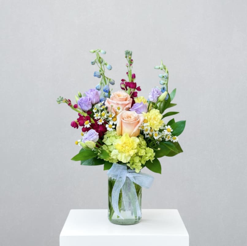 Handpicked for Mom - MOTHER'S DAY COLLECTION | LOCAL DELIVERY ONLY  A sweet and simple bouquet with a "just-picked" feel. Designed in a clear mason jar, this garden-inspired arrangement features a charming mix of green hydrangea, roses, stock, delphinium, lisianthus, carnations, and feverfew. Dainty, cheerful &amp; full of wildflower charm - it's like bringing a bit of the meadow indoors.