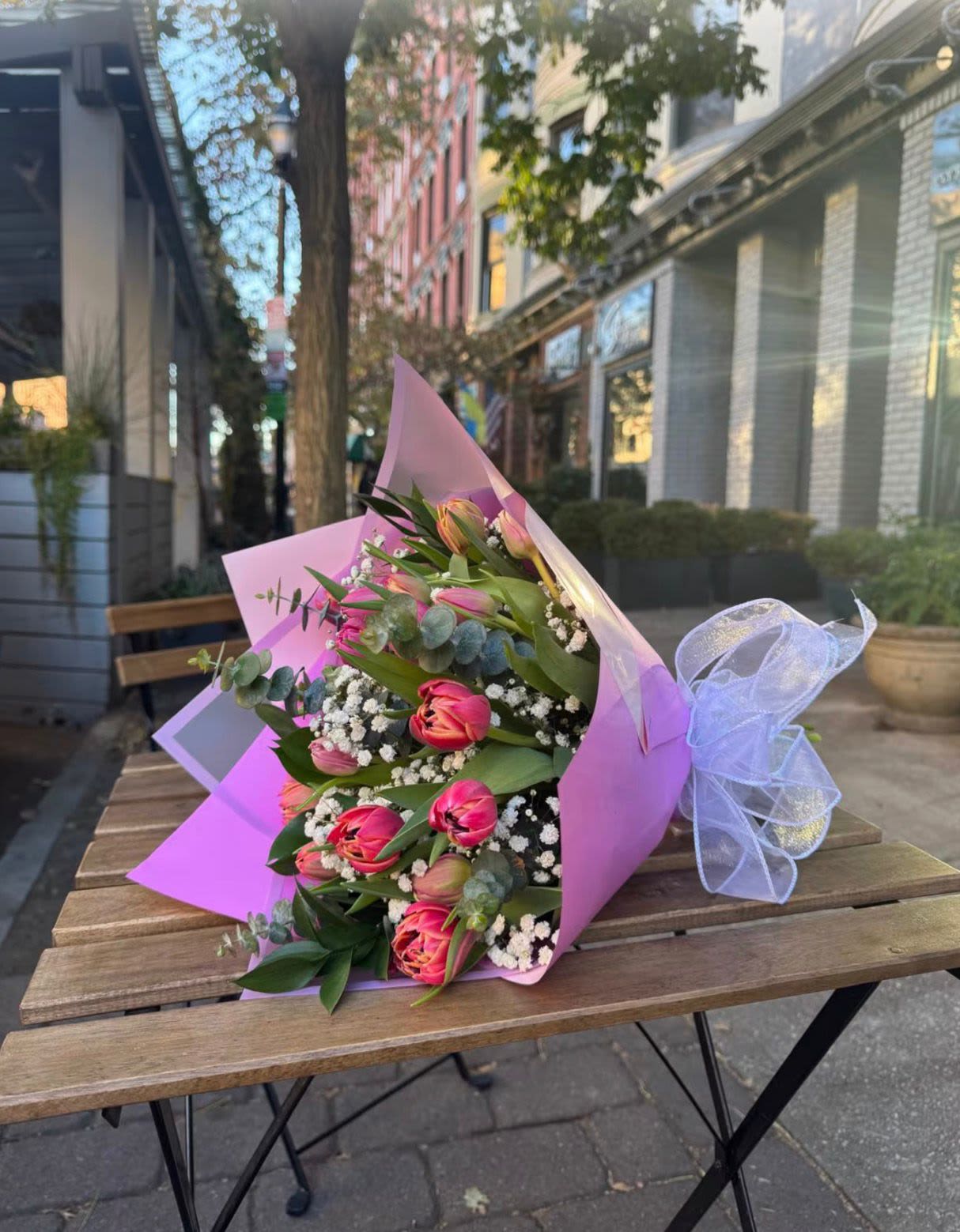 Armonía Tulipán - An elegant bouquet featuring 12 tulips, baby's breath, and greenery, wrapped in Korean-style paper—perfect for gifting to your favorite person on any occasion. The paper color may vary.