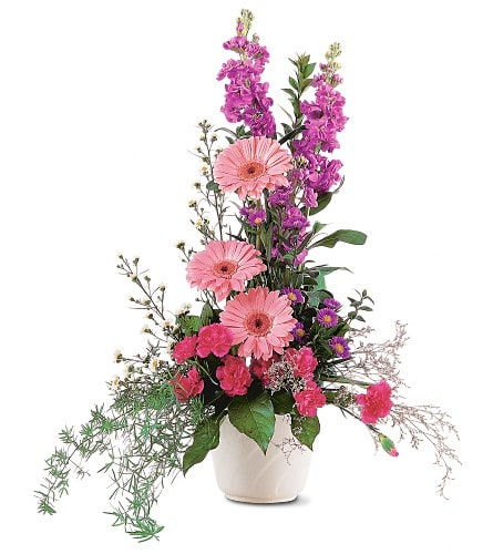 Tall pink and purple floral arrangement in a white vase
