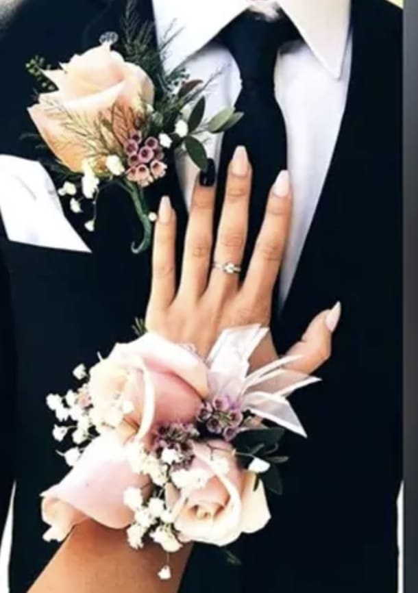 Two floral wrist corsages with pale pink roses and white accents