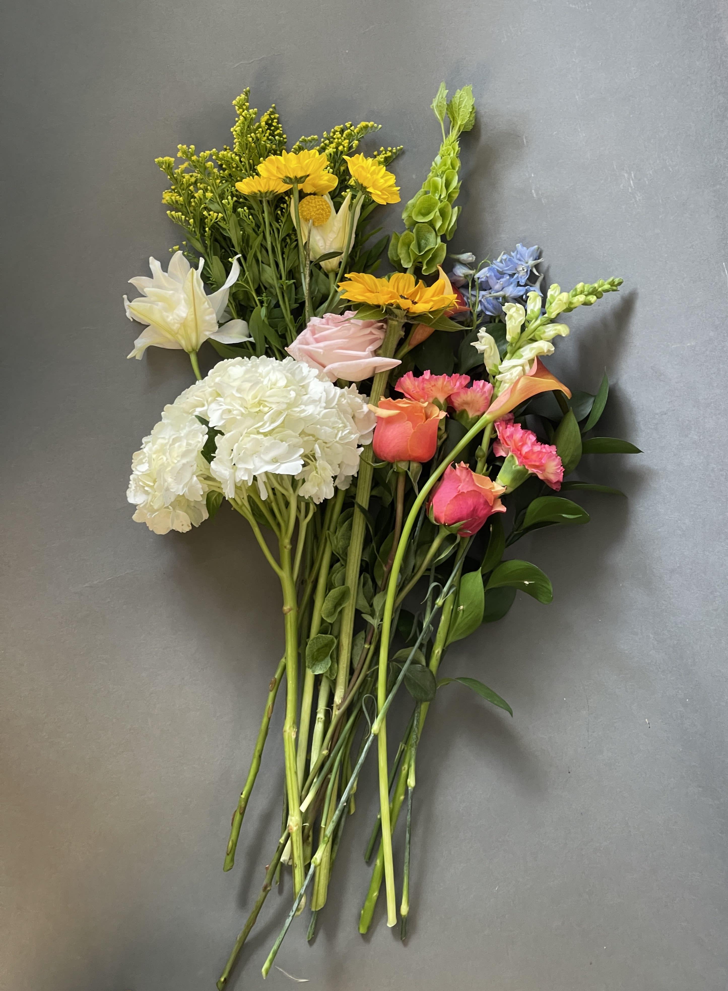 Mixed bouquet with white hydrangea, yellow daisies, pink roses, and snapdragons