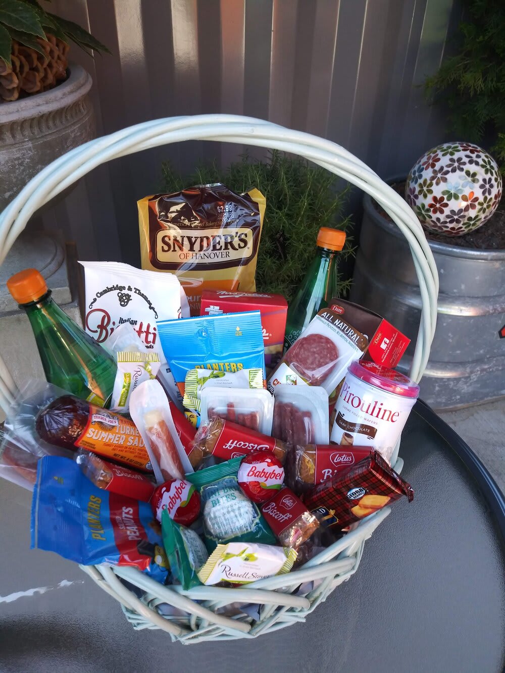 Gift basket filled with assorted snack packages and two bottles