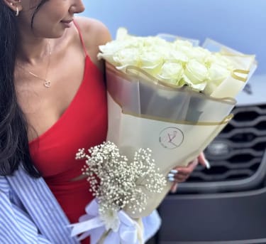 White  Roses Bouquet - 25, 50 &amp;100 Stems - A luxurious bouquet of fresh, premium white roses, carefully selected for their soft color, long stems, and refined beauty. Designed in an elegant European style, this bouquet is wrapped in high-quality materials and finished with a delicate ribbon. Each arrangement is handcrafted to create a clean, sophisticated look that highlights the natural beauty of the roses. Perfect for gifting, celebrations, or simply elevating any moment with timeless elegance. The photo shows 25 roses. The bouquet size will increase based on your selected option.