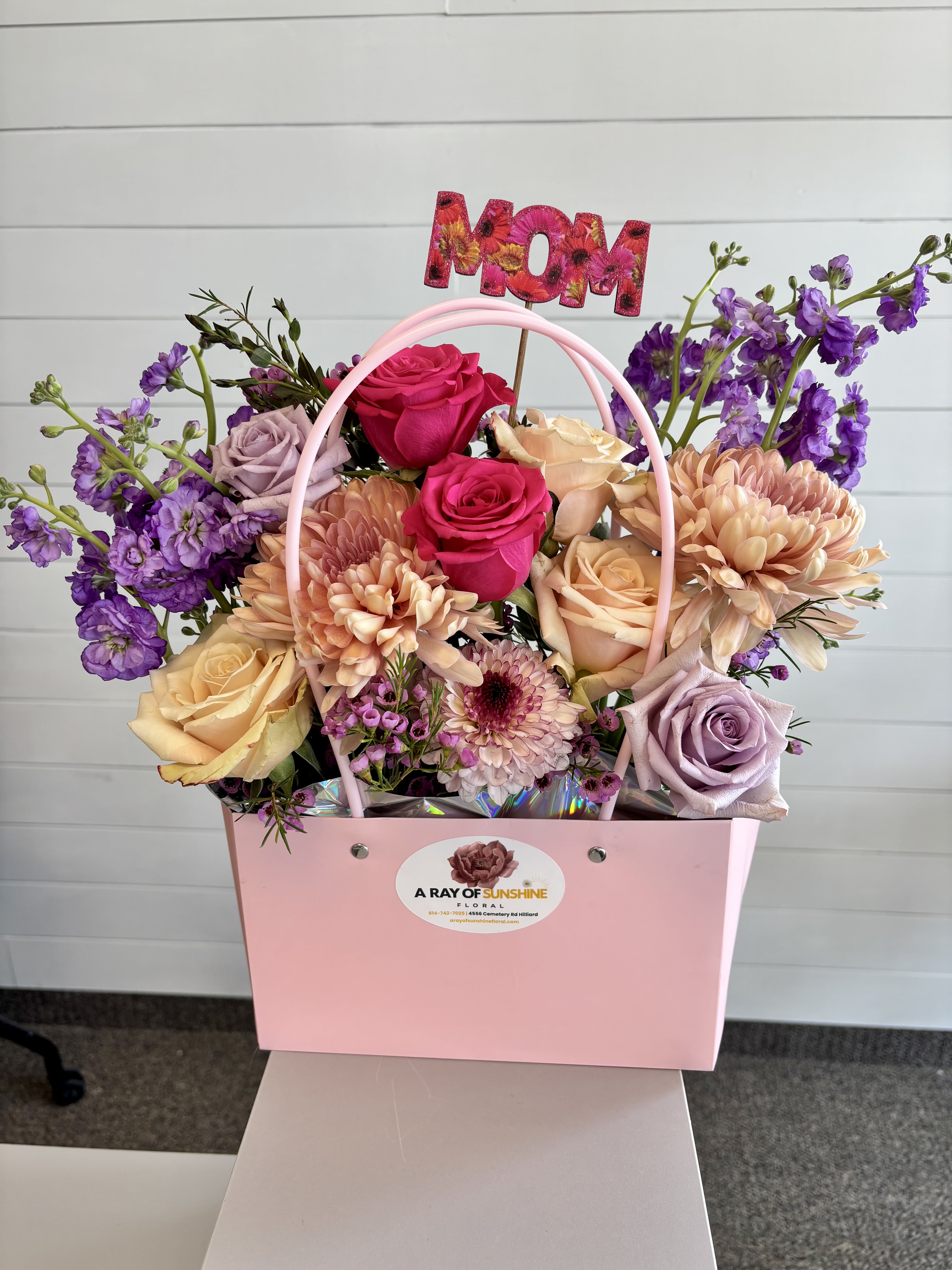The Bloom Bag - A boutique-style arrangement featuring fresh, seasonal flowers artfully designed inside a stylish purse. Thoughtfully arranged for a soft, elegant look… perfect for celebrating Mom with something a little different and memorable.