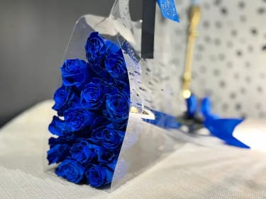 Blue Roses Bouquet - 25, 50 &amp; 100 Stems - A stunning bouquet of blue roses, designed to stand out with its bold and необычный appearance. These roses create a modern and artistic look, perfect for those who want something different and memorable. Carefully wrapped in premium materials and finished with an elegant ribbon, this bouquet makes a striking gift for special occasions or unique celebrations. Choose your preferred size to create the perfect visual impact — from a stylish arrangement to a dramatic, luxurious statement. The photo shows 25 roses. The bouquet size will increase based on your selected option.