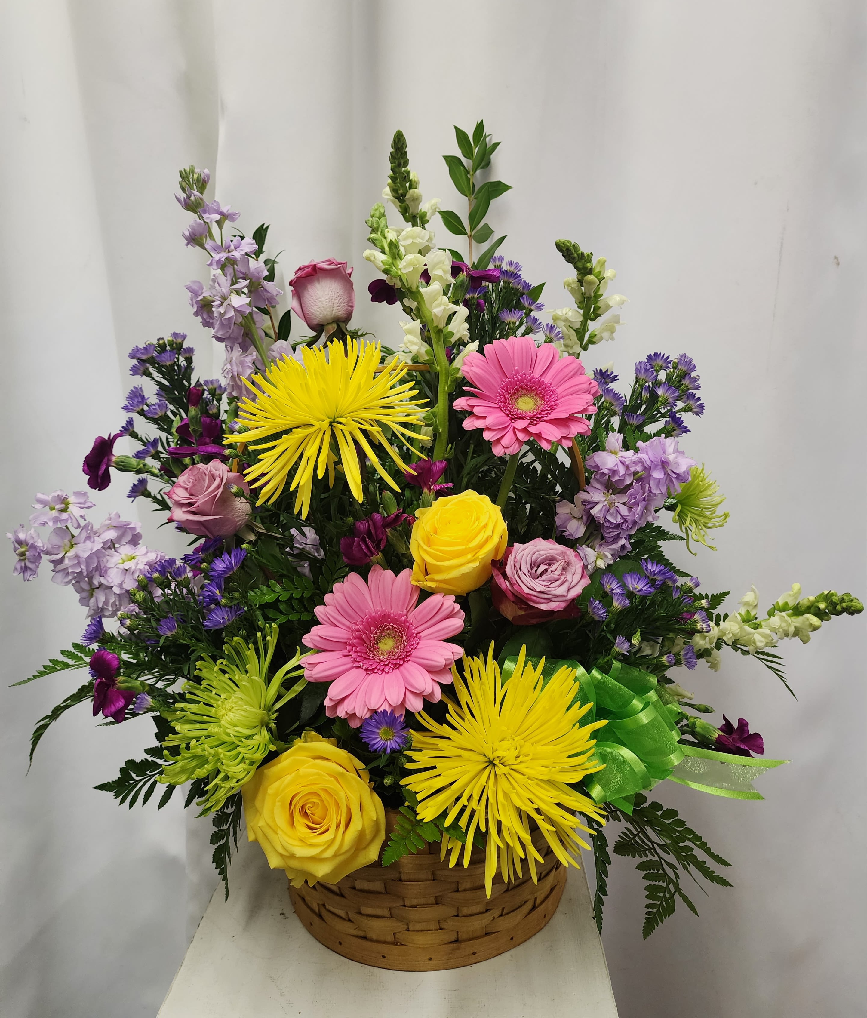 Colorful Radiance - A bright and heartfelt expression of support, this uplifting sympathy basket blends vibrant blooms in a warm honeytan woven base. Bursting with cheerful color and fresh seasonal flowers, it offers a comforting reminder of light, love, and beautiful memories during difficult times. 
