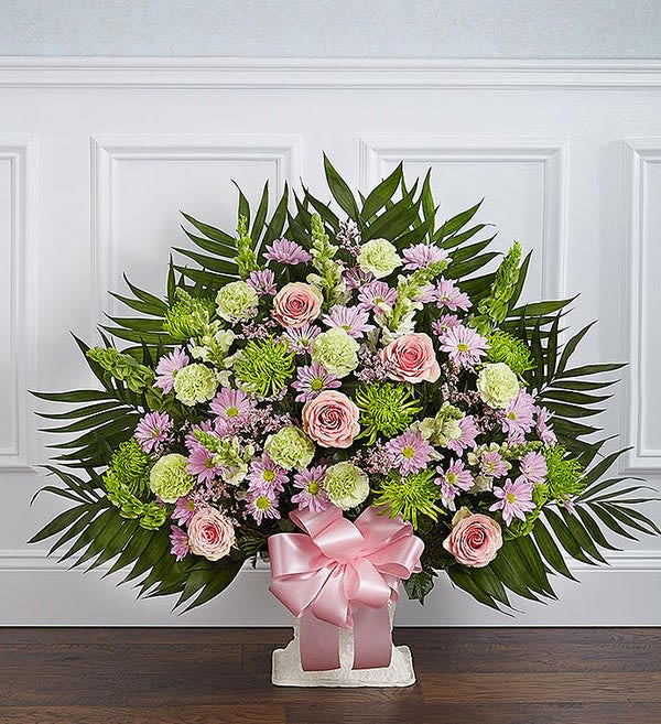 Large floral standing spray with pink roses and lavender daisies on a white stand