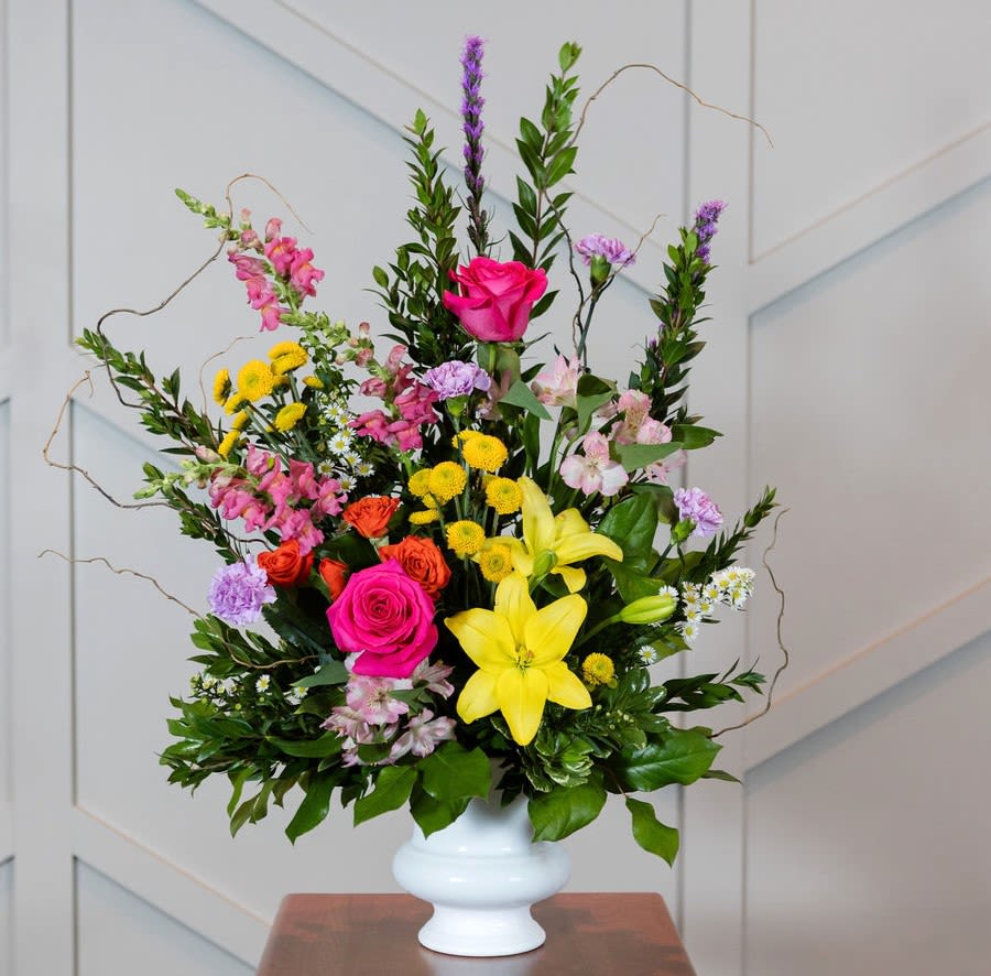 Mixed bouquet with pink roses and yellow lilies in a white vase