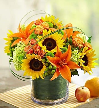 Sunflower and orange lily bouquet in a glass vase