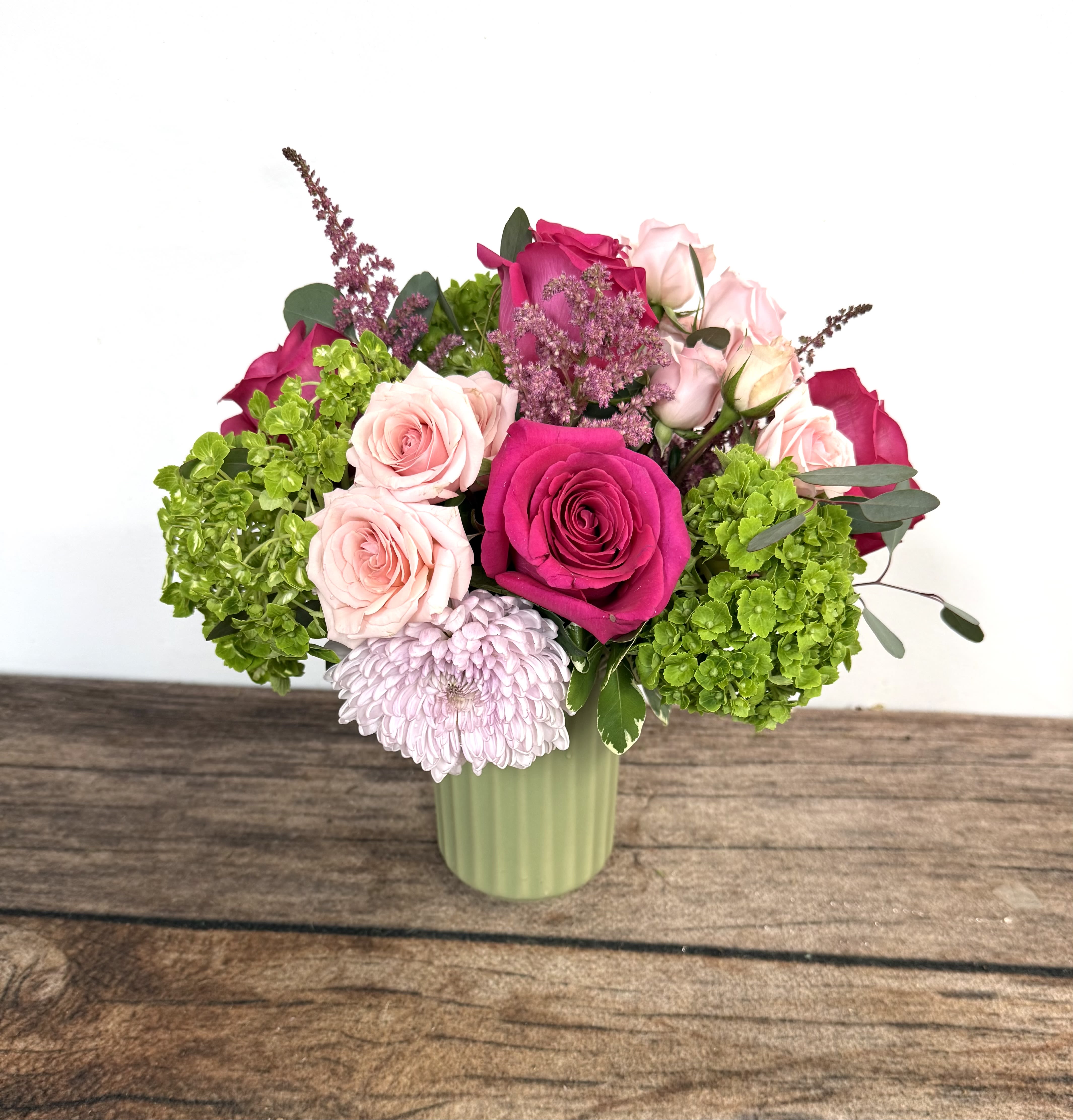 Opal - Textured ceramic vase with bright, seasonal blooms.