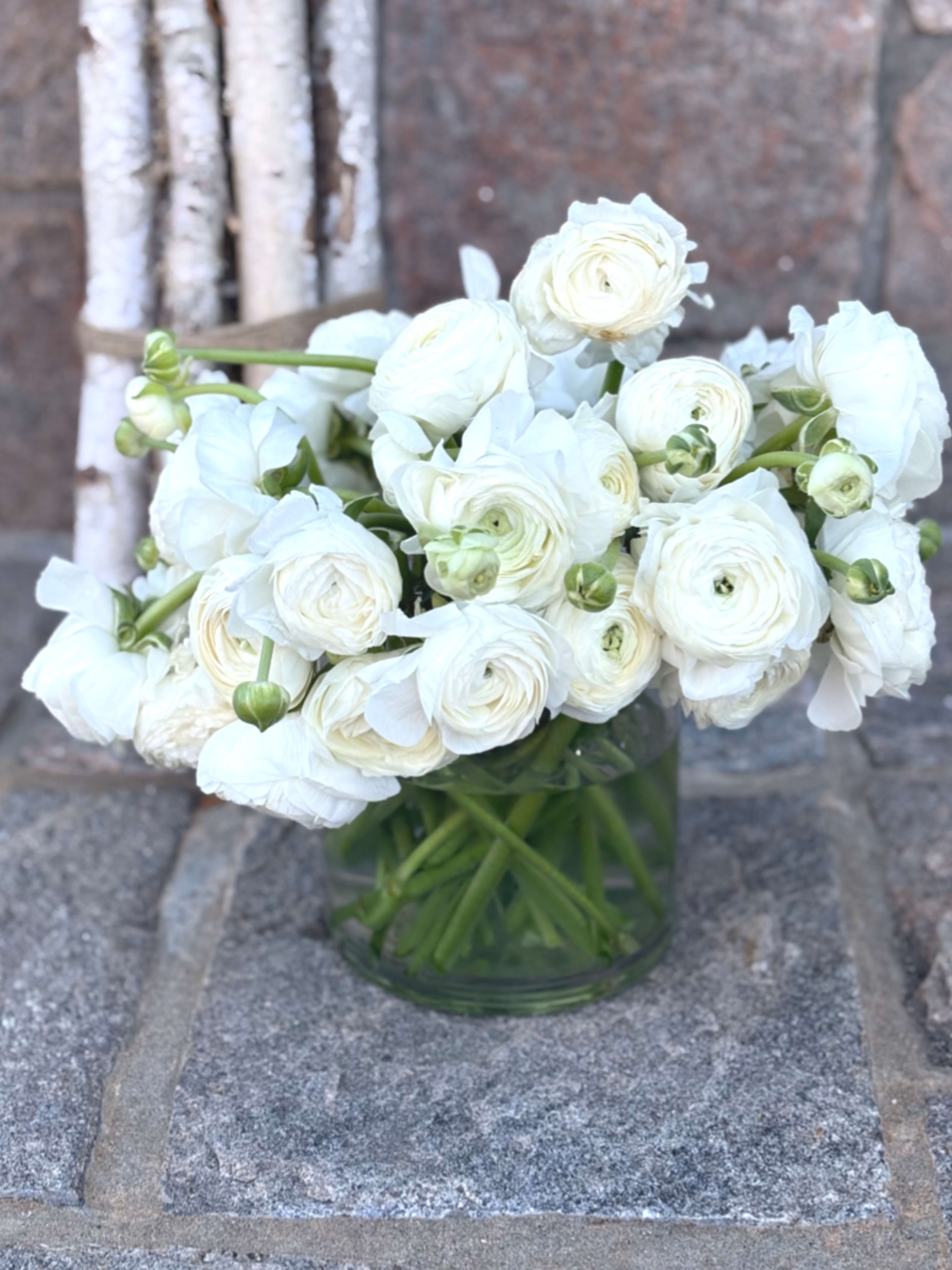 White ranunculus bouquet in a clear glass vase