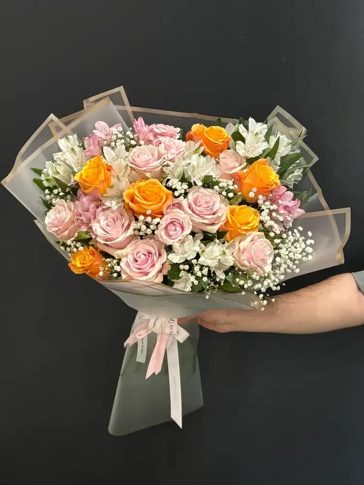 Blush &amp; Sunset Rose Bouquet - This bouquet is a beautiful harmony of softness and vibrant energy. It features delicate blush pink roses paired with rich orange roses, creating a striking yet elegant contrast full of warmth and life. Light white accents, including airy baby’s breath and soft blooms, add freshness and balance, giving the arrangement a refined and graceful finish. Perfect for birthdays, thank-you gifts, or simply to brighten someone’s day, this bouquet delivers a feeling of joy, warmth, and effortless elegance. Designed in a modern European style and wrapped in elegant neutral paper, it reflects a premium, clean, and timeless aesthetic. Each bouquet is handcrafted and may vary slightly, making every arrangement unique and personal.