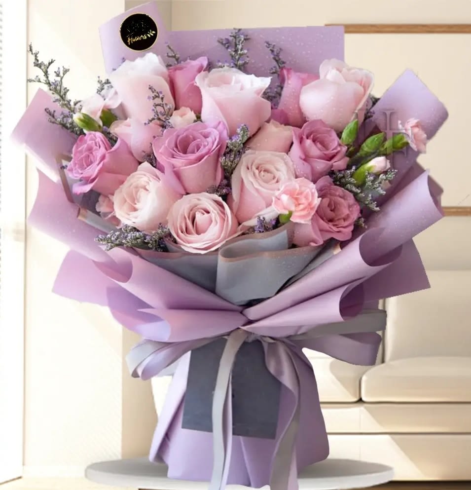 Bouquet of pink and lavender roses wrapped in purple paper