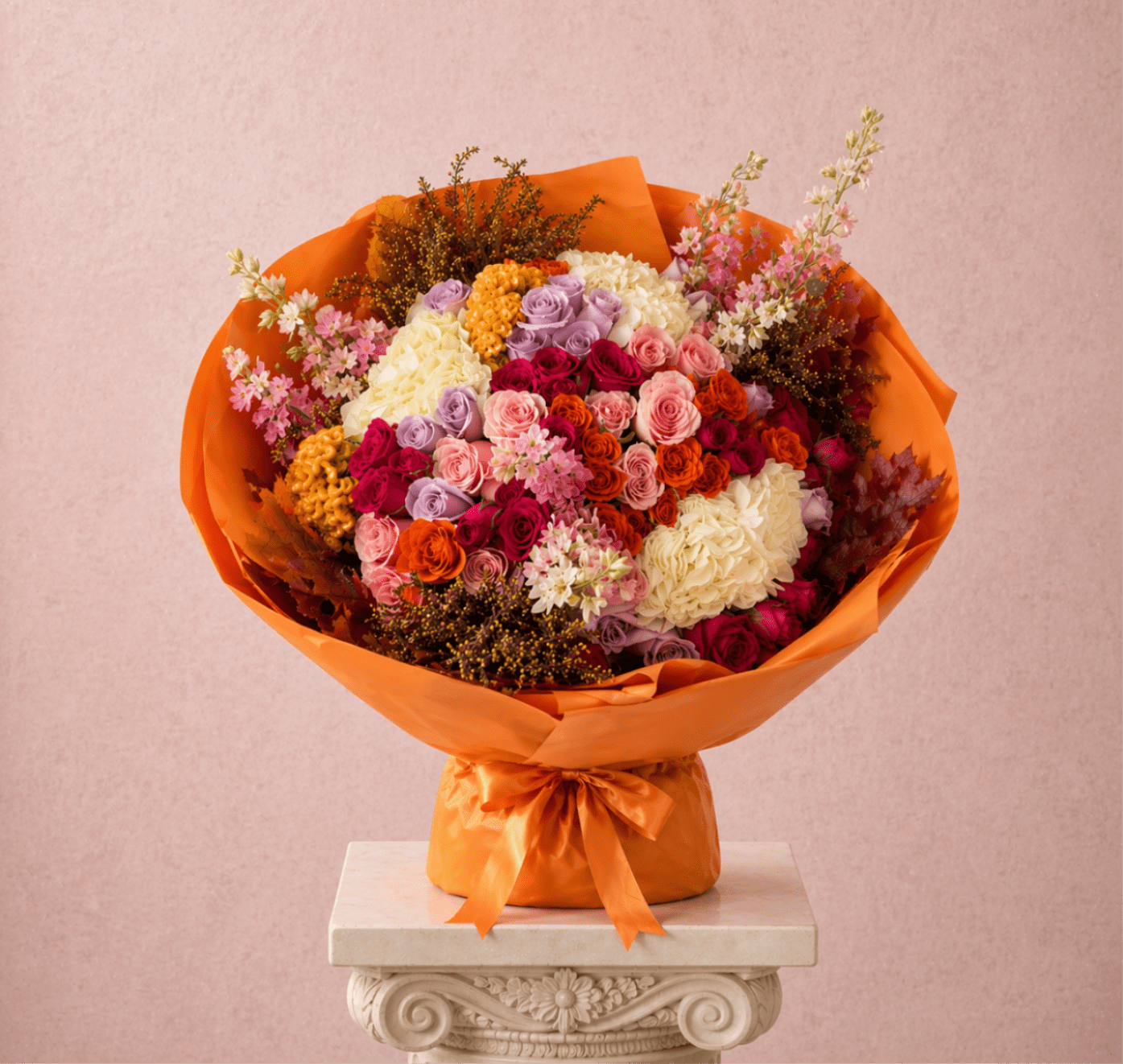 Mixed bouquet of colorful roses wrapped in bright orange paper