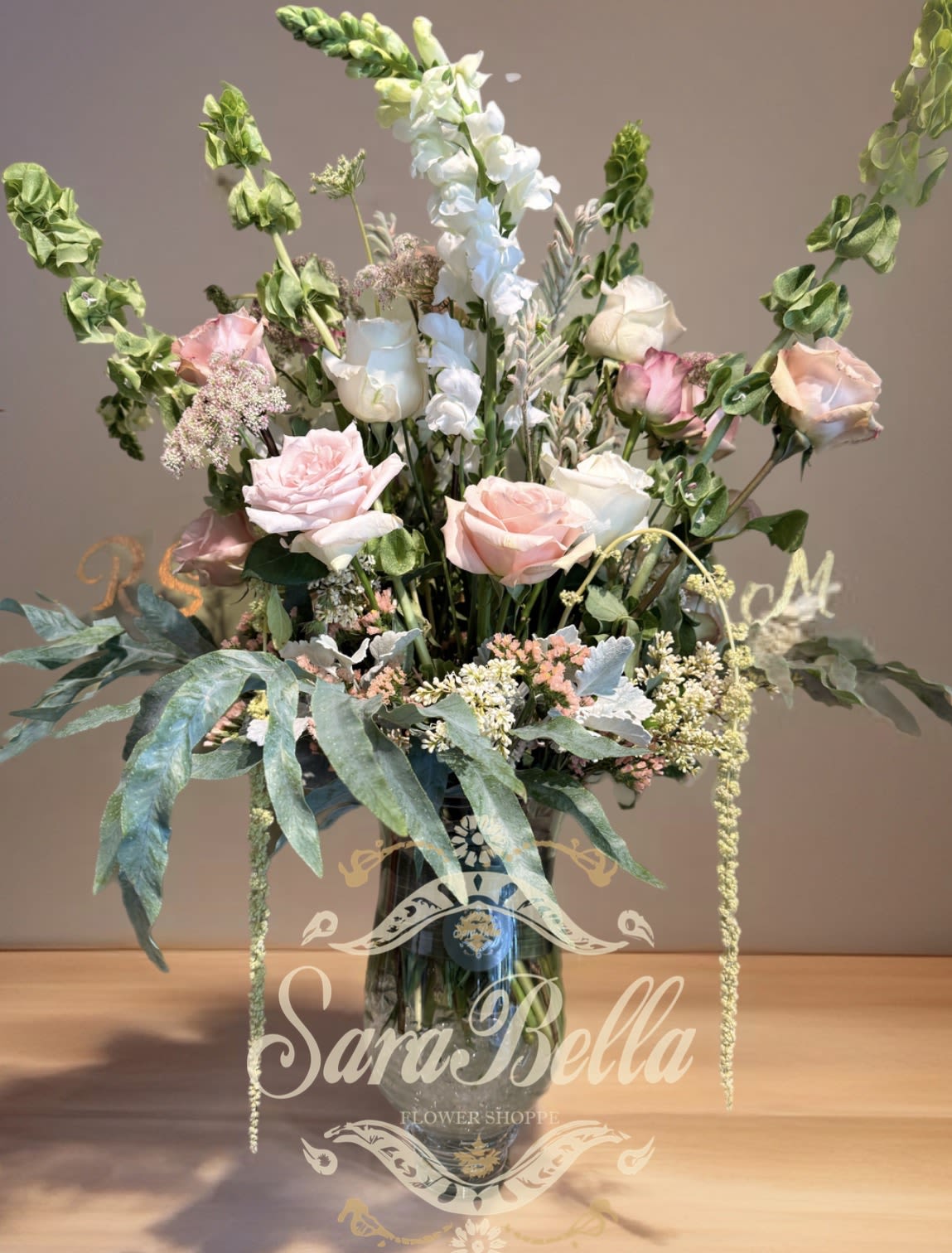 SOFT STEMS - "This exquisite floral arrangement is a delicate blend of blush pink roses, creamy white snapdragons, and soft greenery. Each bloom is chosen to evoke grace and serenity, making it perfect for weddings, anniversaries, or as a heartfelt gesture of love."