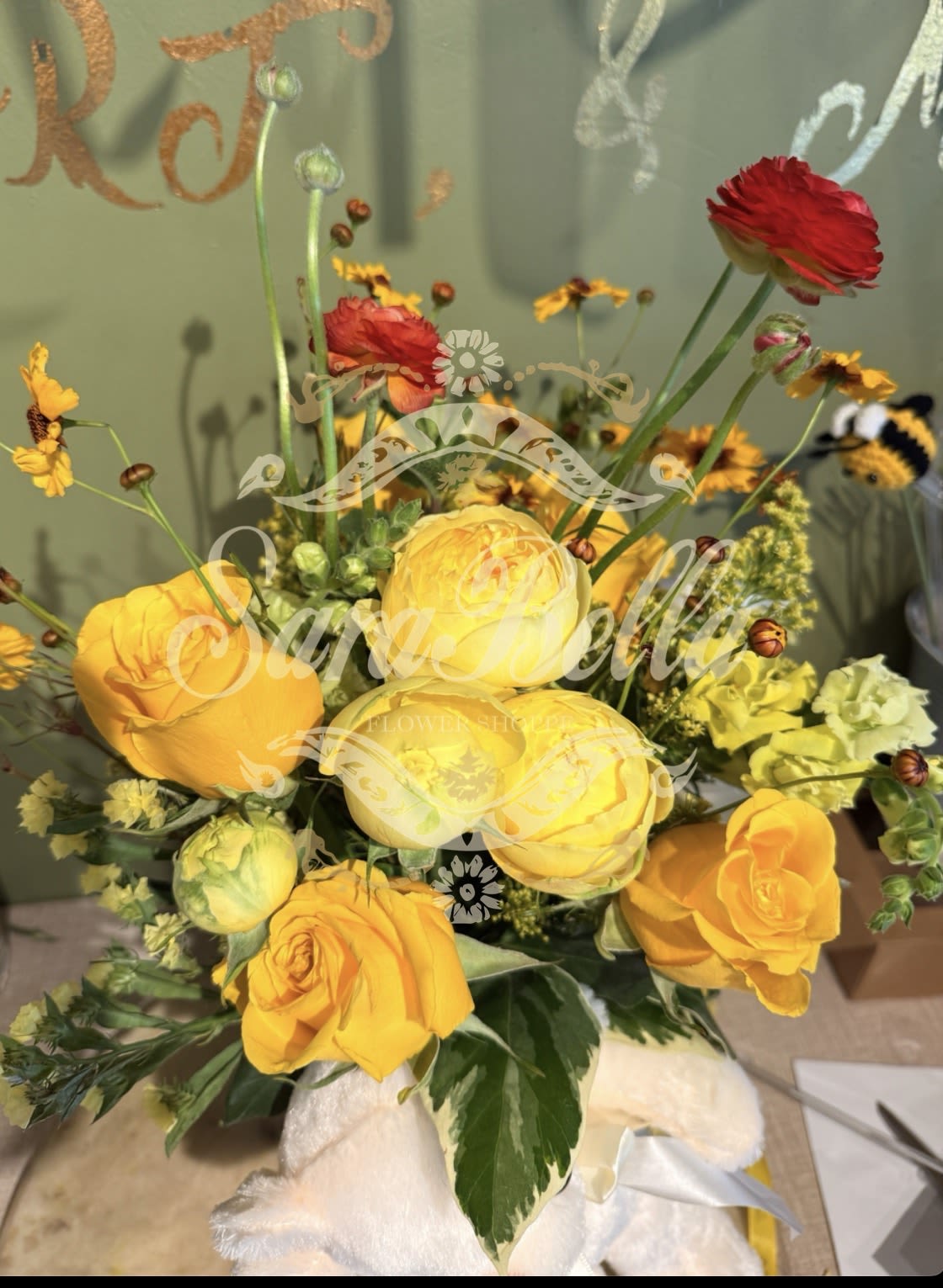 Sunshine Surprise - “A bright and cheerful arrangement of golden roses and seasonal blooms, designed to bring warmth, joy, and a touch of sunshine to any space.