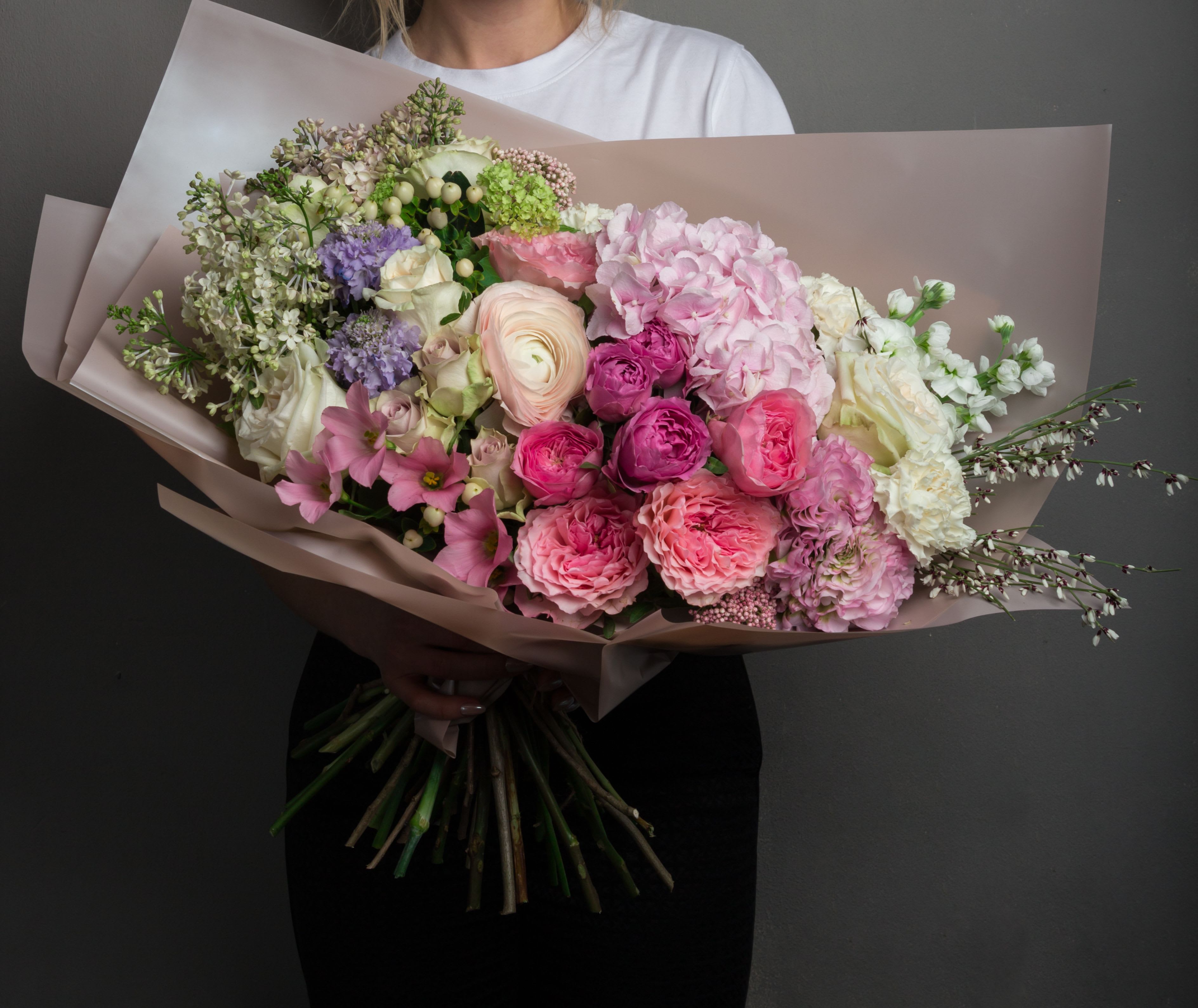 Large pastel bouquet with pink, white, and lavender flowers wrapped in blush paper