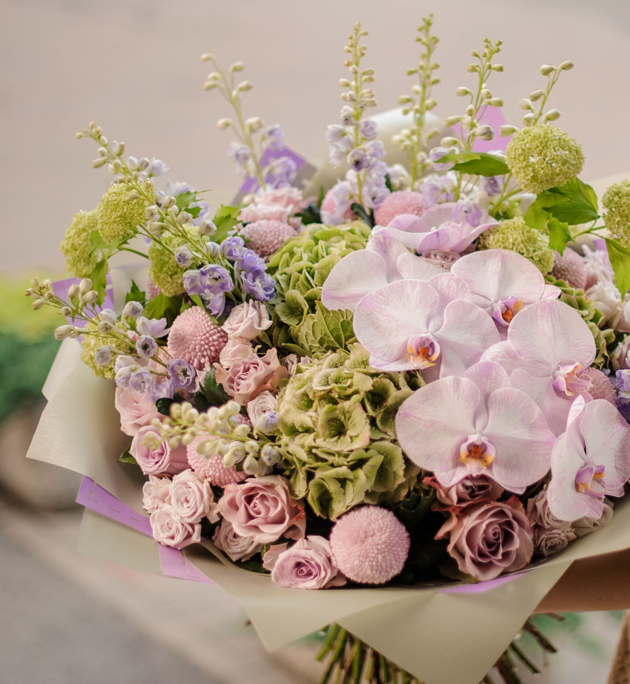 Bouquet of pale pink orchids, roses, and green hydrangeas