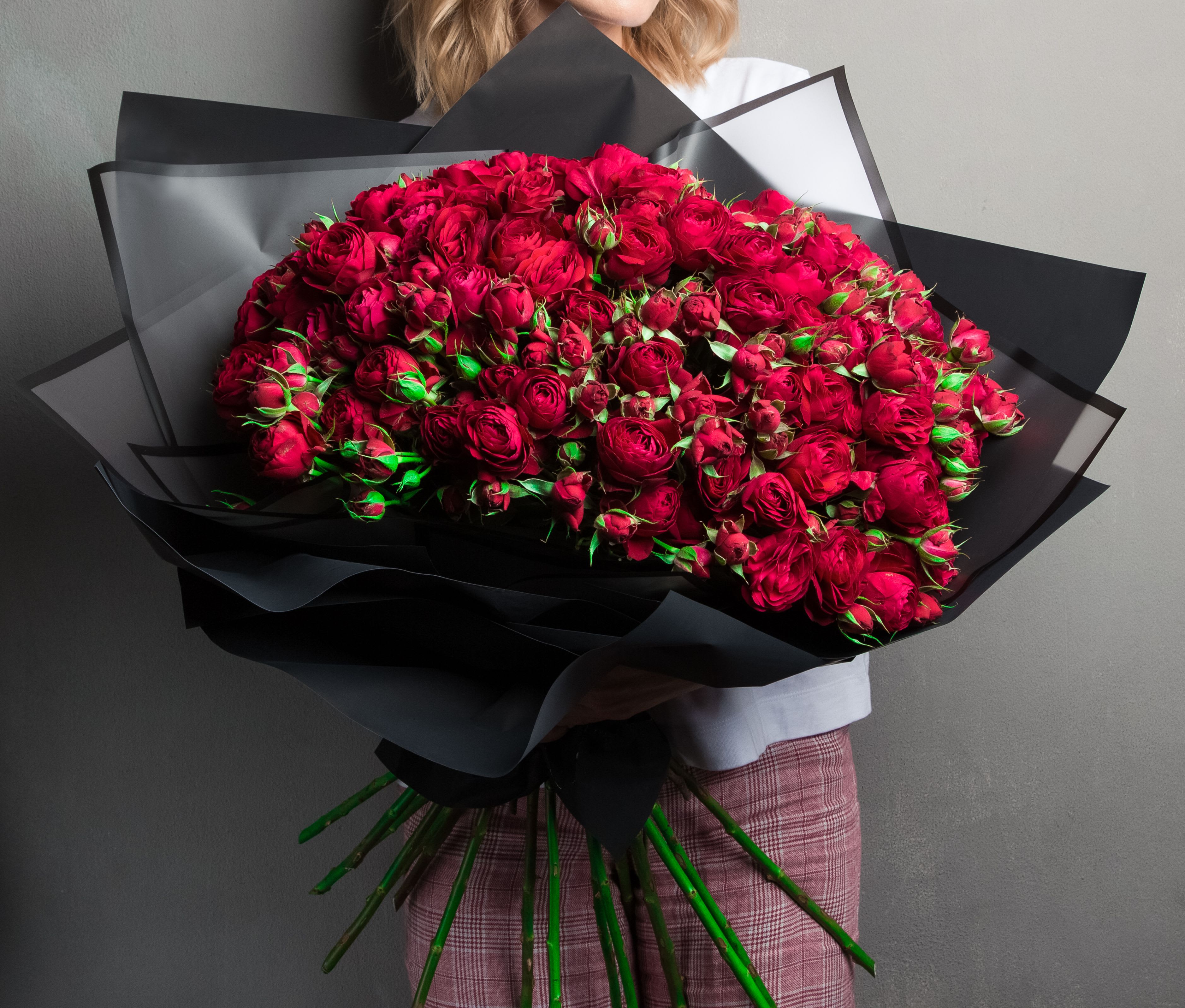 Large bouquet of deep red roses wrapped in black paper