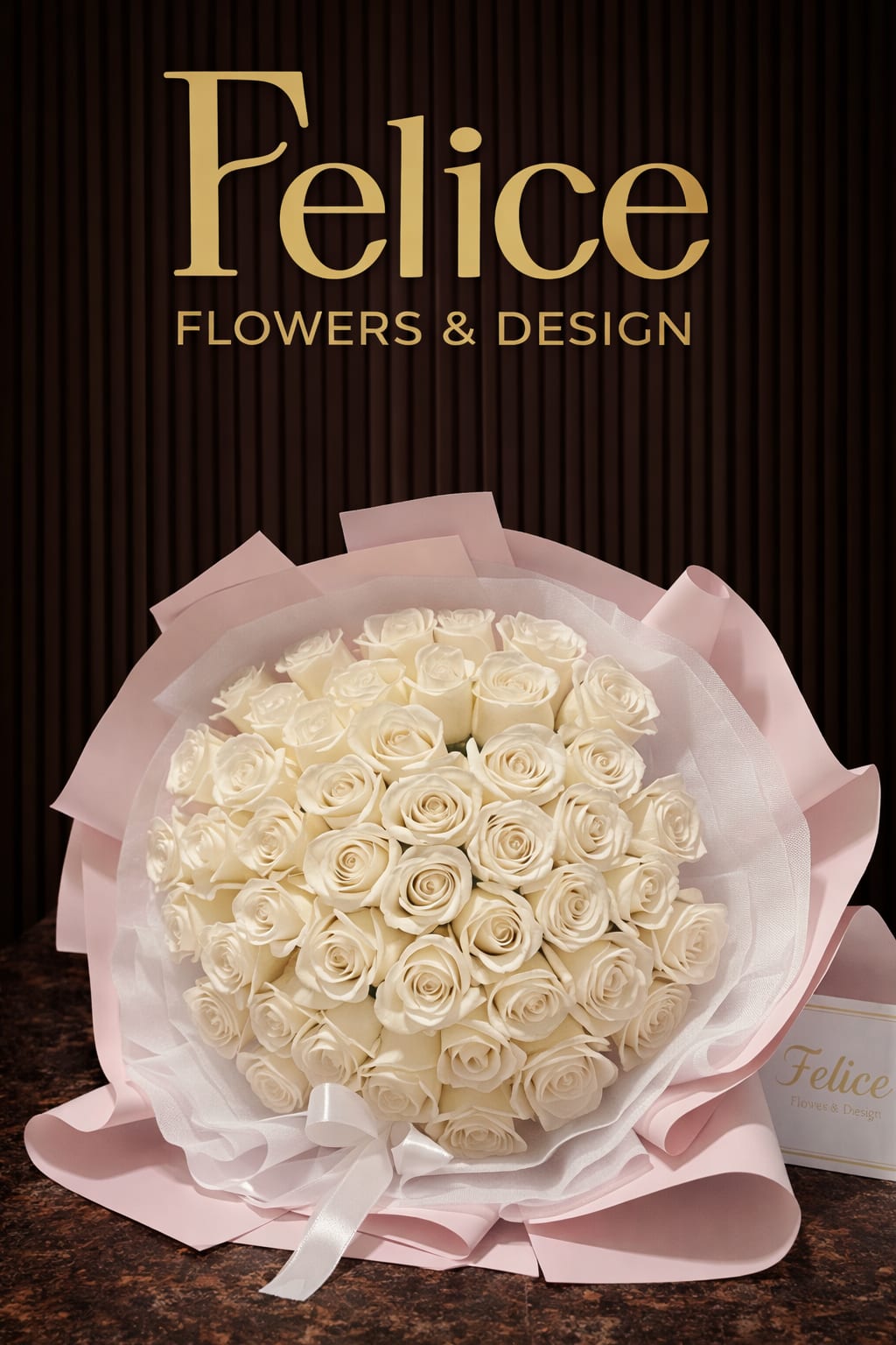 Bouquet of white roses wrapped in pale pink paper with a ribbon