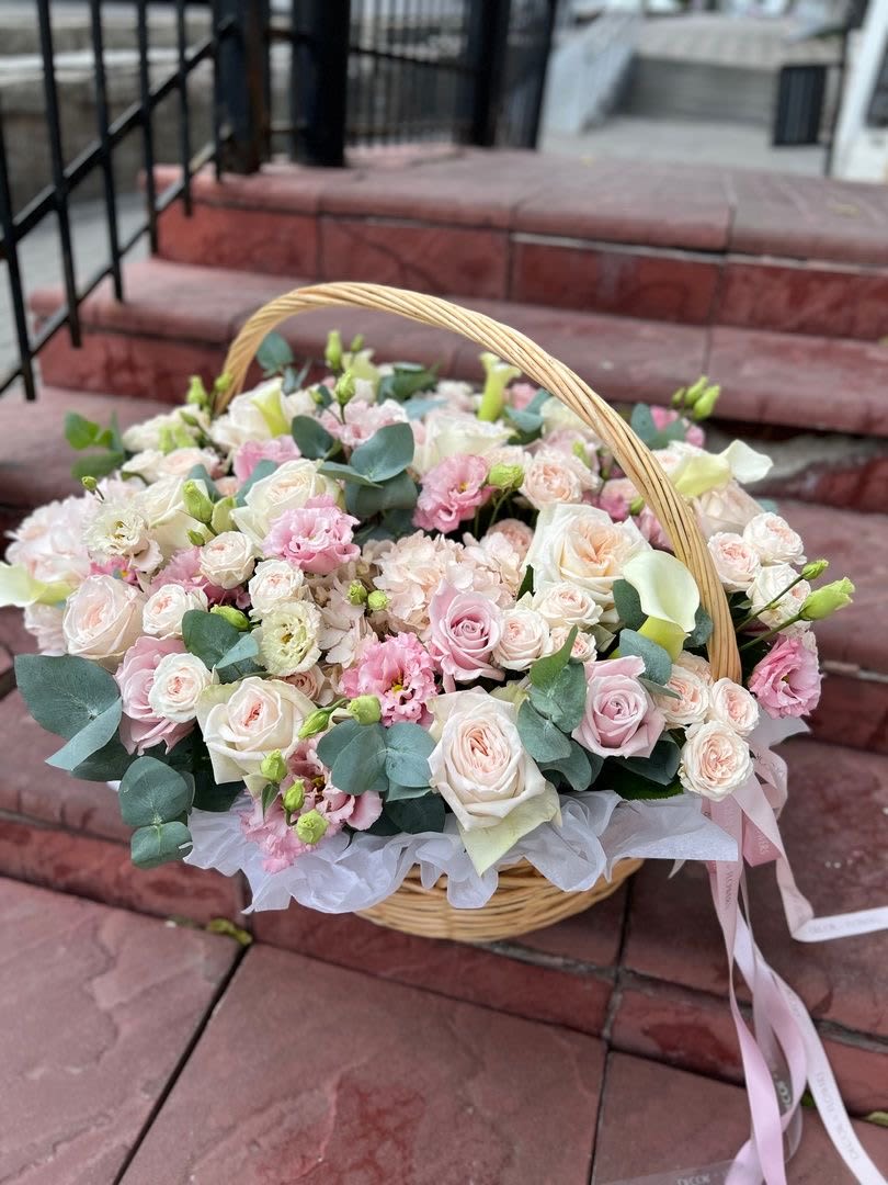 “Sweet Harmony Basket for Mom”.  - This delicate floral basket is a heartfelt tribute for Mother’s Day. Inside, soft roses stand out, from pale pink to white, combined with lisianthus, mini carnations, and delicate seasonal blooms. Eucalyptus adds freshness, with its vibrant green and subtle fragrance. Each flower is carefully chosen and arranged in a natural wicker basket, adorned with a soft pink ribbon. This basket is not just a gift for Mom, but also for Grandma, your mother-in-law, or any special mother figure. It is an elegant and tender gesture, expressing gratitude and love on this meaningful day.