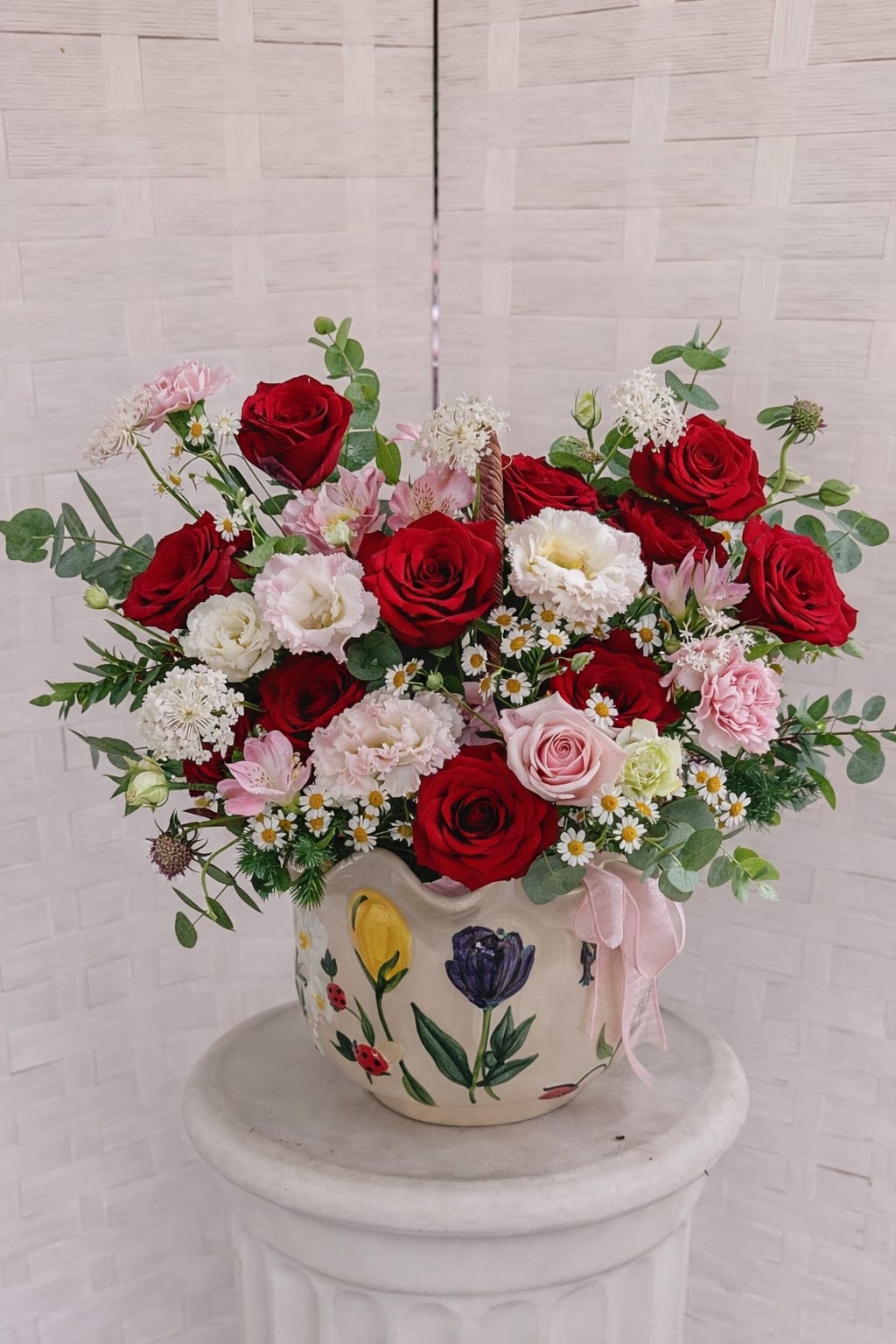 Garden of Artisan for mom  -  This delicate floral arrangement, presented in a hand-painted ceramic vase, is a heartfelt tribute for Mother’s Day. It includes red roses, pink roses, lisianthus, carnations, alstroemerias, and aromatic touches of eucalyptus and chamomile. Each flower is chosen to honor our moms, grandmothers, mothers-in-law, and wives. It is a gift that, beyond the flowers, becomes a symbol of love and a lasting memory.