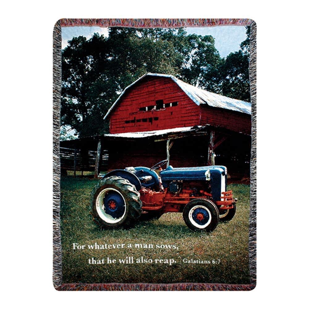A woven blanket with a farm scene and a tractor