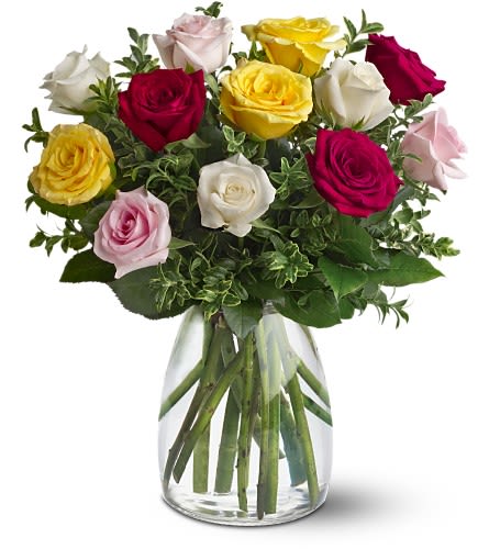 Mixed roses in pink, red, yellow, and white in a clear glass vase