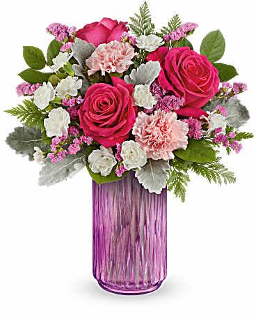 Pink roses and carnations in a purple glass vase