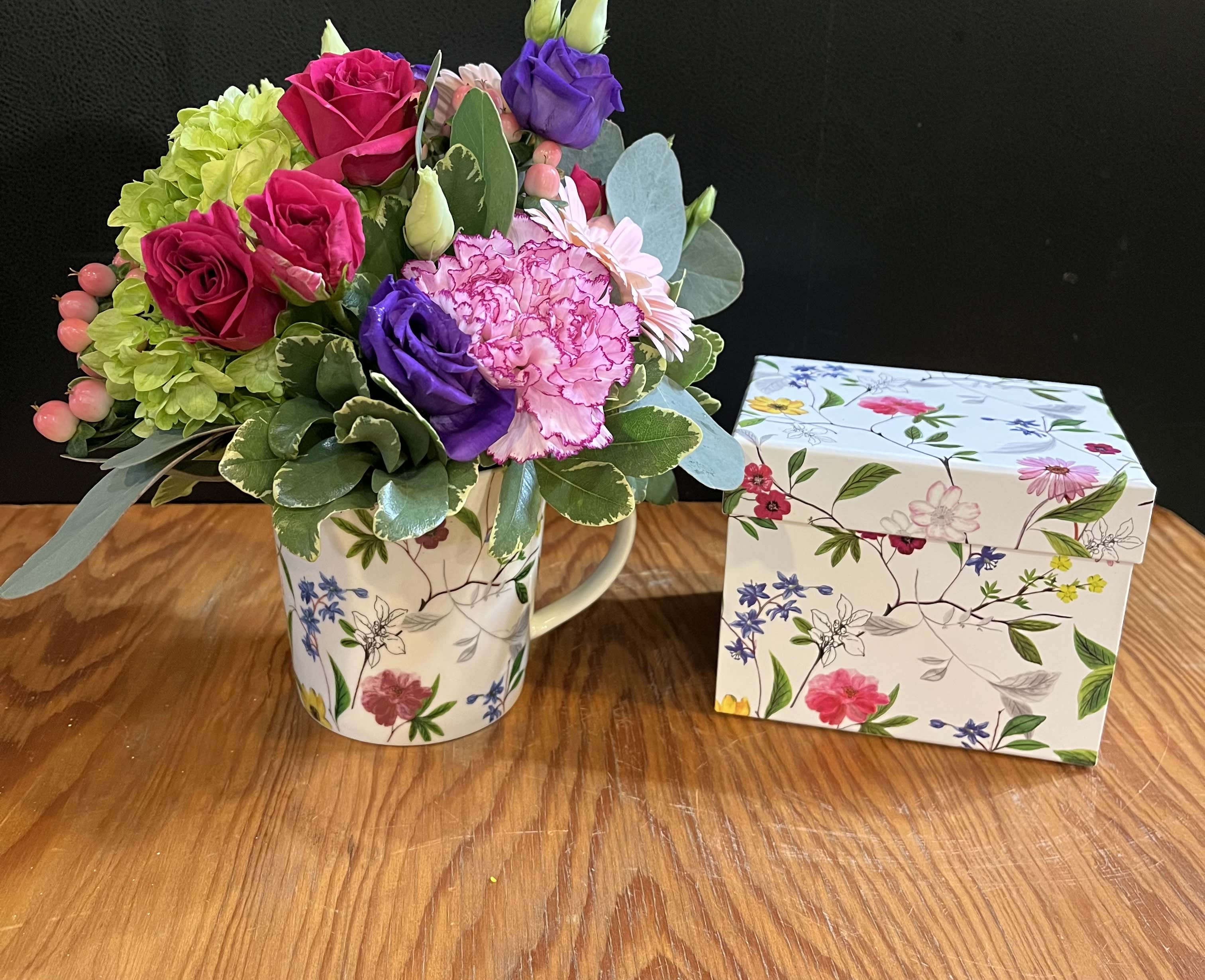 Mixed bouquet in a floral mug beside a matching gift box