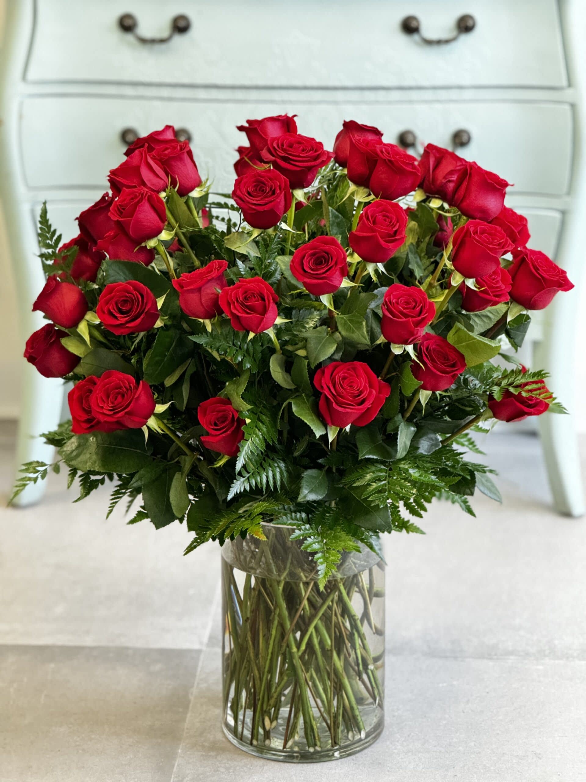 Red roses arranged in a clear glass vase