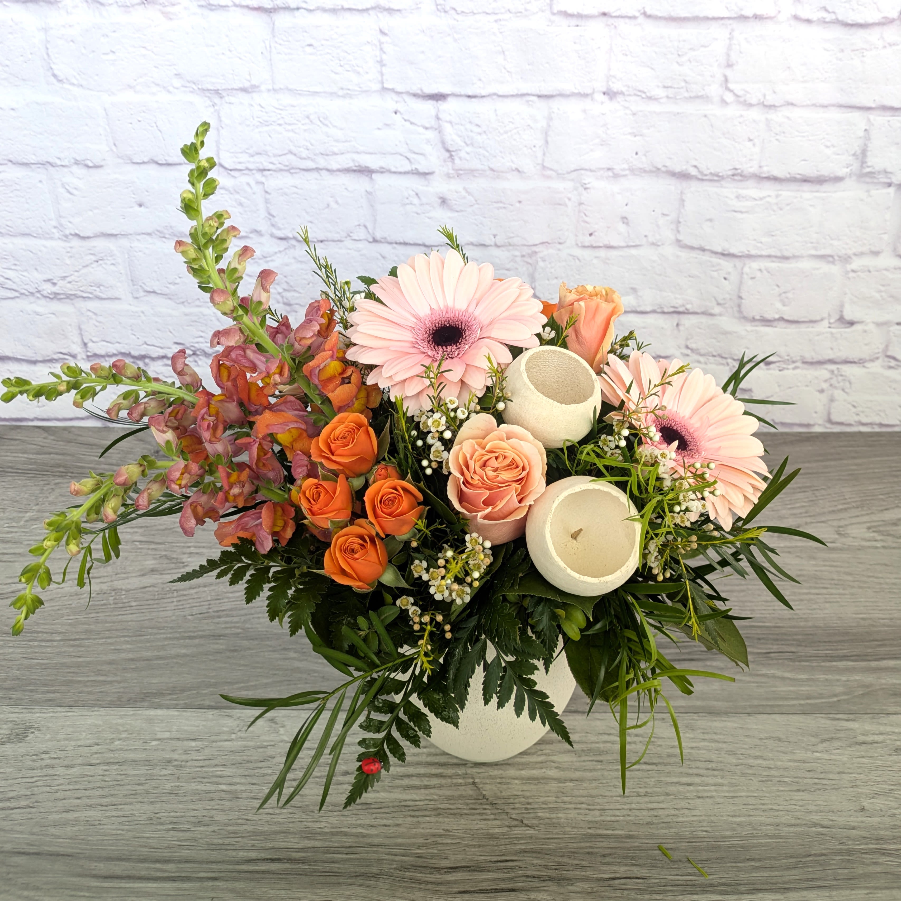 Fruit Cup - Fruit Cup is A Ladybug Floral exclusive bouquet. This bouquet includes gerbera daisies, snap dragons, roses, spray roses, dried bell cups and wax flowers. Featured in a 5.5” stone inspired concrete bowl.  Orientation: All Around 13” Tall 13” Wide  