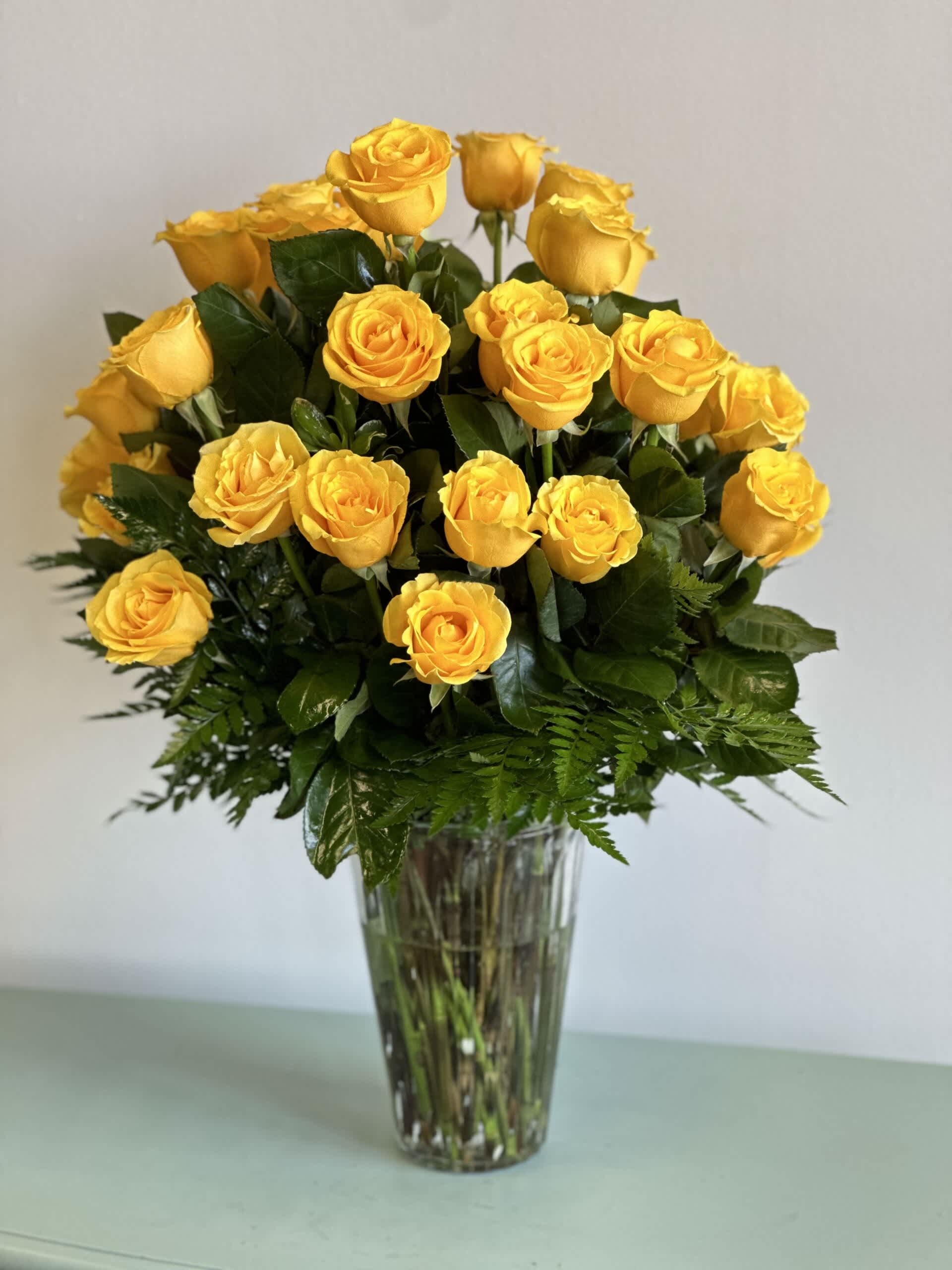Yellow roses arranged in a clear glass vase
