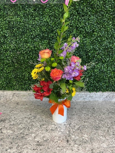 Mixed bouquet in a white vase with an orange ribbon