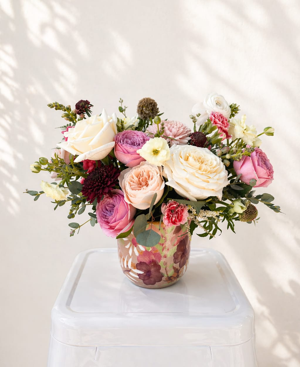 Garden in Bloom, for Mom - Celebrate spring and Mother’s Day with Garden in Bloom, a handcrafted floral arrangement designed to capture the beauty of the season. Made to order with a fresh selection of seasonal blooms like garden roses, ranunculus, and delicate filler flowers, this garden-inspired design brings effortless elegance to any space.  Each arrangement is thoughtfully styled with lush textures, soft petals, and airy greenery for a natural, garden-grown aesthetic. Finished in a hand-painted ceramic floral pot, it makes a beautiful keepsake and a perfect choice for Mother’s Day flowers.