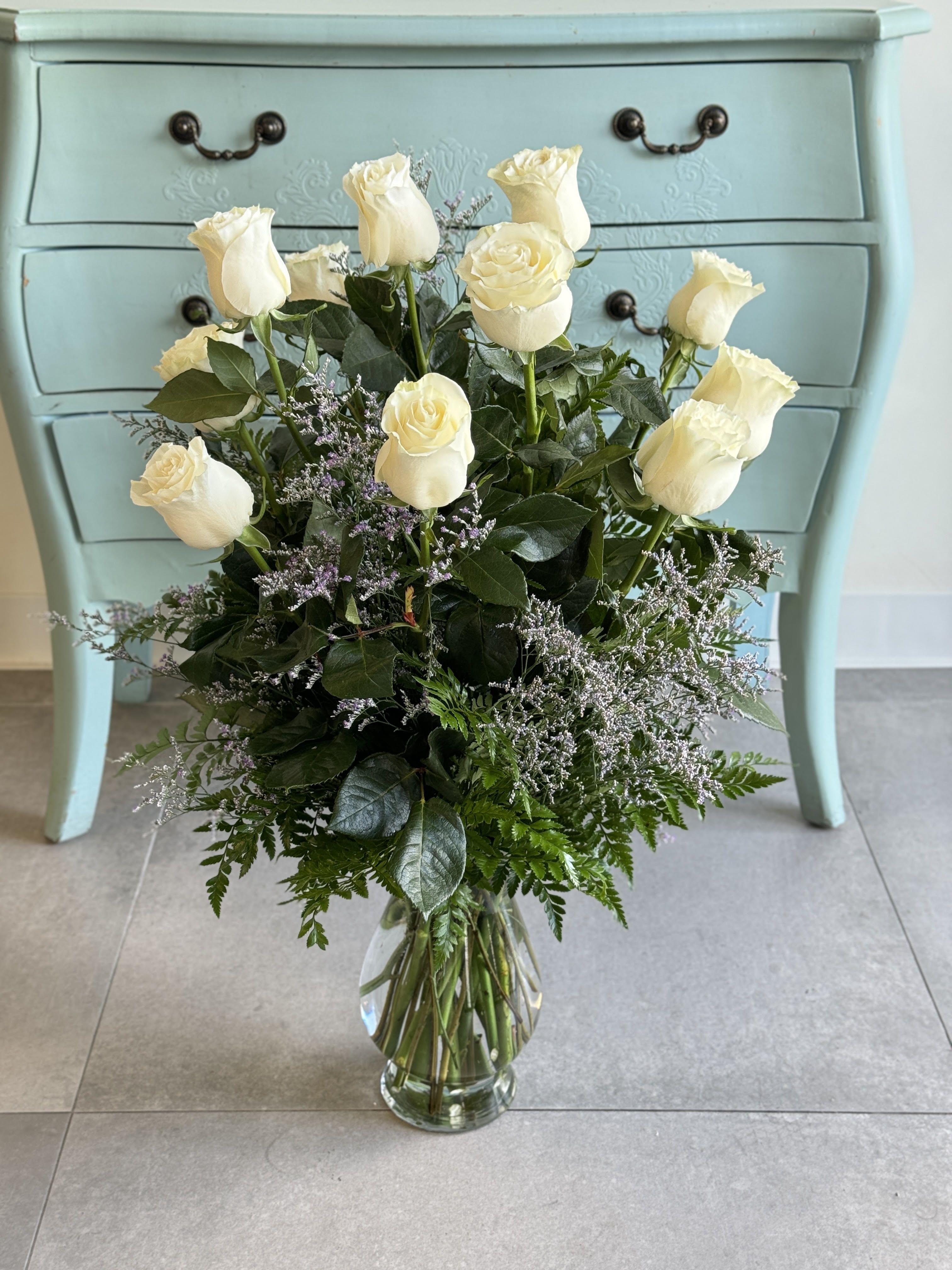 White roses arranged in a clear glass vase