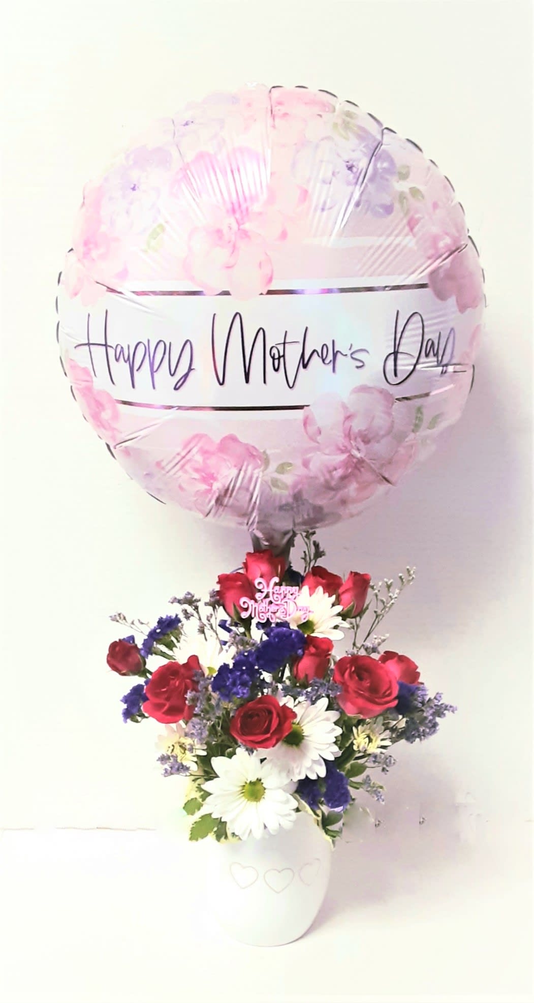 Mother's Day balloon above a red, white, and purple flower arrangement in a white pot