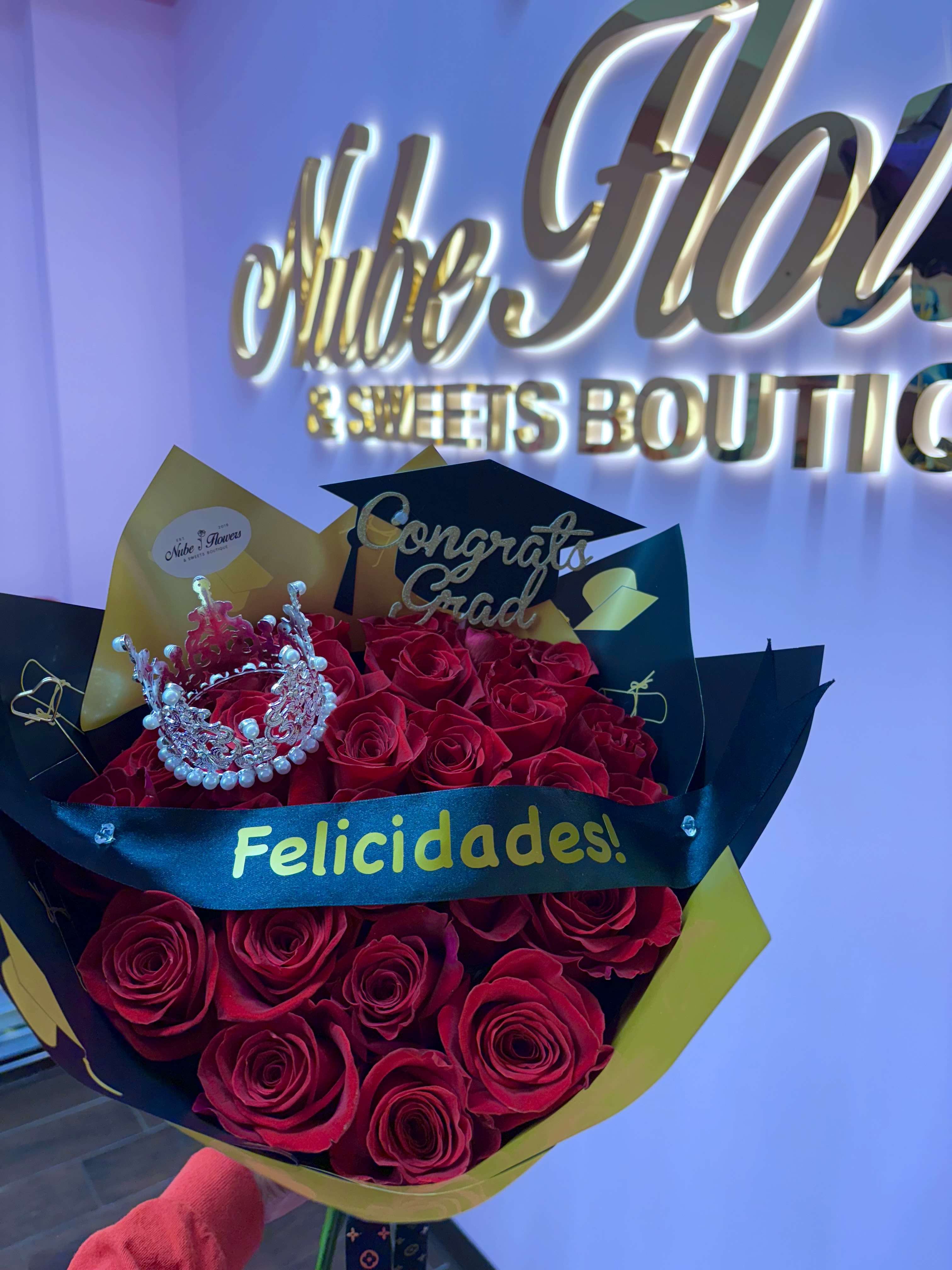 Bouquet of red roses with a small crown and graduation topper