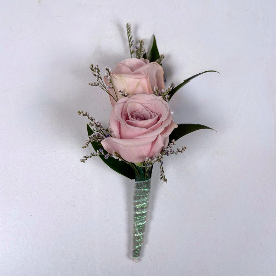 Amethyst Boutonniere - With Wrap - Soft pale lavender roses take center stage in this Amethyst boutonniere, a romantic boutonniere perfect for weddings, proms, or anniversary wear. The two lavender spray roses are paired with tiny white and lavender filler sprigs and slender dark green leaves, creating a compact, diagonal composition with gentle texture and movement. The overall palette of lavender, white and green keeps the look soft and versatile.  This version of the design features the shimmering iridescent ribbon pictured, and a boutonniere pin is included so it sits neatly on a suit or jacket. If you want to change the color of either the ribbon wrap or add dazzling sparkle accents to your boutonniere, check out our add-ons and pick your desired color.