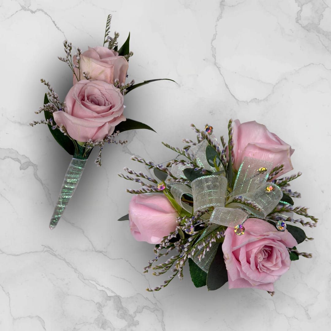 Amethyst 3 Rose Combo - Make ordering prom flowers a breeze this year with our Amethyst 3 Rose Combo! This combo comes with our Amethyst Boutonniere - With Wrap and our Amethyst 3 Rose Corsage, perfectly matched together to make a stunning, coordinating look.  The Amethyst 3 Rose Corsage features three pale lavender roses and fine filler, finished with sheer iridescent ribbon loops and small iridescent rhinestone gems for a touch of sparkle. Hand-assembled to sit comfortably on the wrist with a white lace wristlet, it's small, neatly constructed, and designed to coordinate with formalwear and pastel palettes.   The Amethyst Boutonniere - With Wrap features two lavender spray roses, paired with tiny white and lavender filler sprigs and slender dark green leaves, all wrapped together with the shimmering iridescent ribbon pictured, and a boutonniere pin is included so it sits neatly on a suit or jacket. 