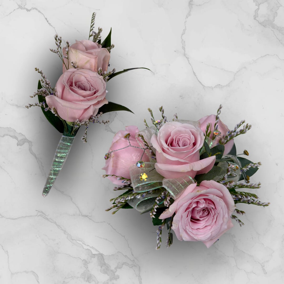 Amethyst 4 Rose Combo - Make ordering prom flowers a breeze this year with our Amethyst 4 Rose Combo! This combo comes with our Amethyst Boutonniere - With Wrap and our Amethyst 4 Rose Corsage, perfectly matched together to make a stunning, coordinating look.  The Amethyst 3 Rose Corsage features four pale lavender roses and fine filler, finished with sheer iridescent ribbon loops and small iridescent rhinestone gems for a touch of sparkle. Hand-assembled to sit comfortably on the wrist with a white lace wristlet, it's small, neatly constructed, and designed to coordinate with formalwear and pastel palettes.   The Amethyst Boutonniere - With Wrap features two lavender spray roses, paired with tiny white and lavender filler sprigs and slender dark green leaves, all wrapped together with the shimmering iridescent ribbon pictured, and a boutonniere pin is included so it sits neatly on a suit or jacket. 