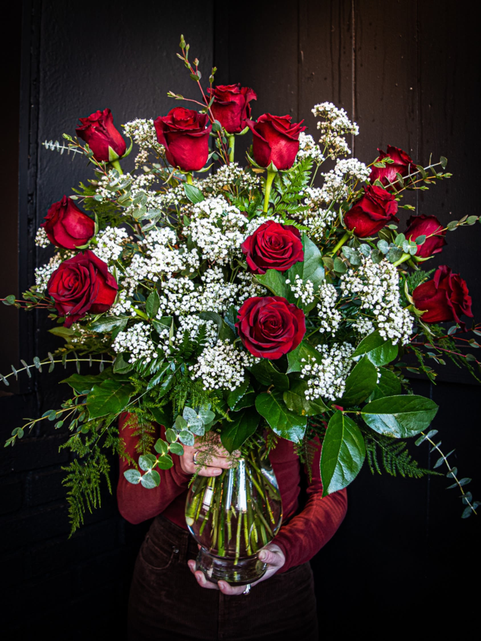 Bouquet of red roses and white filler flowers in a glass vase