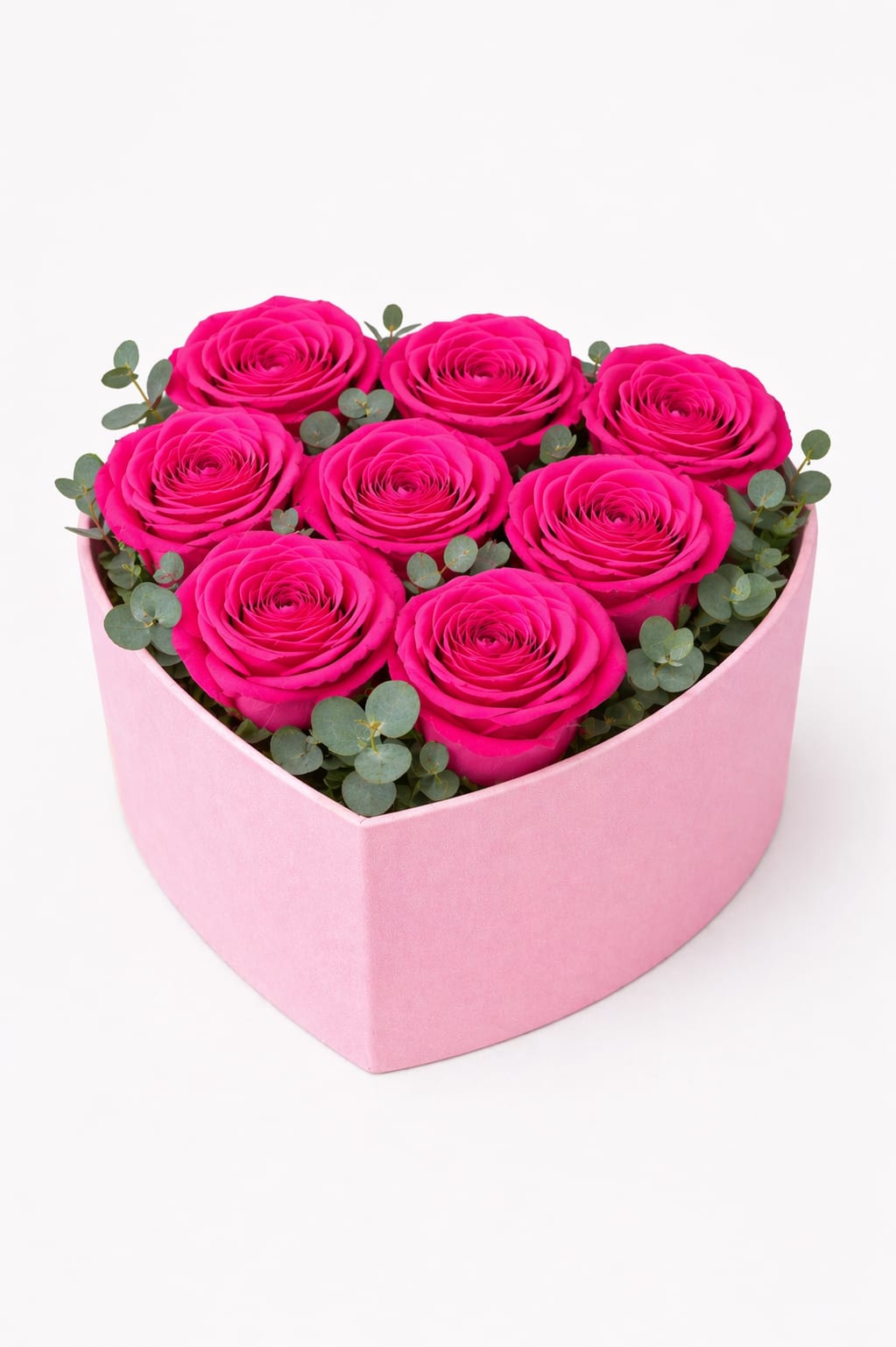 Hot Pink Roses Heart Box | Luxury Rose Arrangement - A bold and elegant expression of love, this design features 8 premium hot pink roses beautifully arranged in a soft blush heart-shaped box. Vibrant in color and refined in presentation, this arrangement is accented with fresh eucalyptus for a modern, elevated touch.  Each rose is carefully selected and placed to create a compact, lush look that highlights the beauty of every bloom. The heart-shaped box adds a romantic and stylish element, making this a meaningful and eye-catching gift.  Better for: Mother’s Day, anniversaries, birthdays, romantic gestures, or just because.  Designed by Studio K Floral Boutique, this piece offers a perfect balance of charm and sophistication — ideal for thoughtful gifting.  Delivery Note: Arrangement will be delivered approximately as shown. Substitutions may occur based on seasonal availability while maintaining the overall look, style, and color palette.