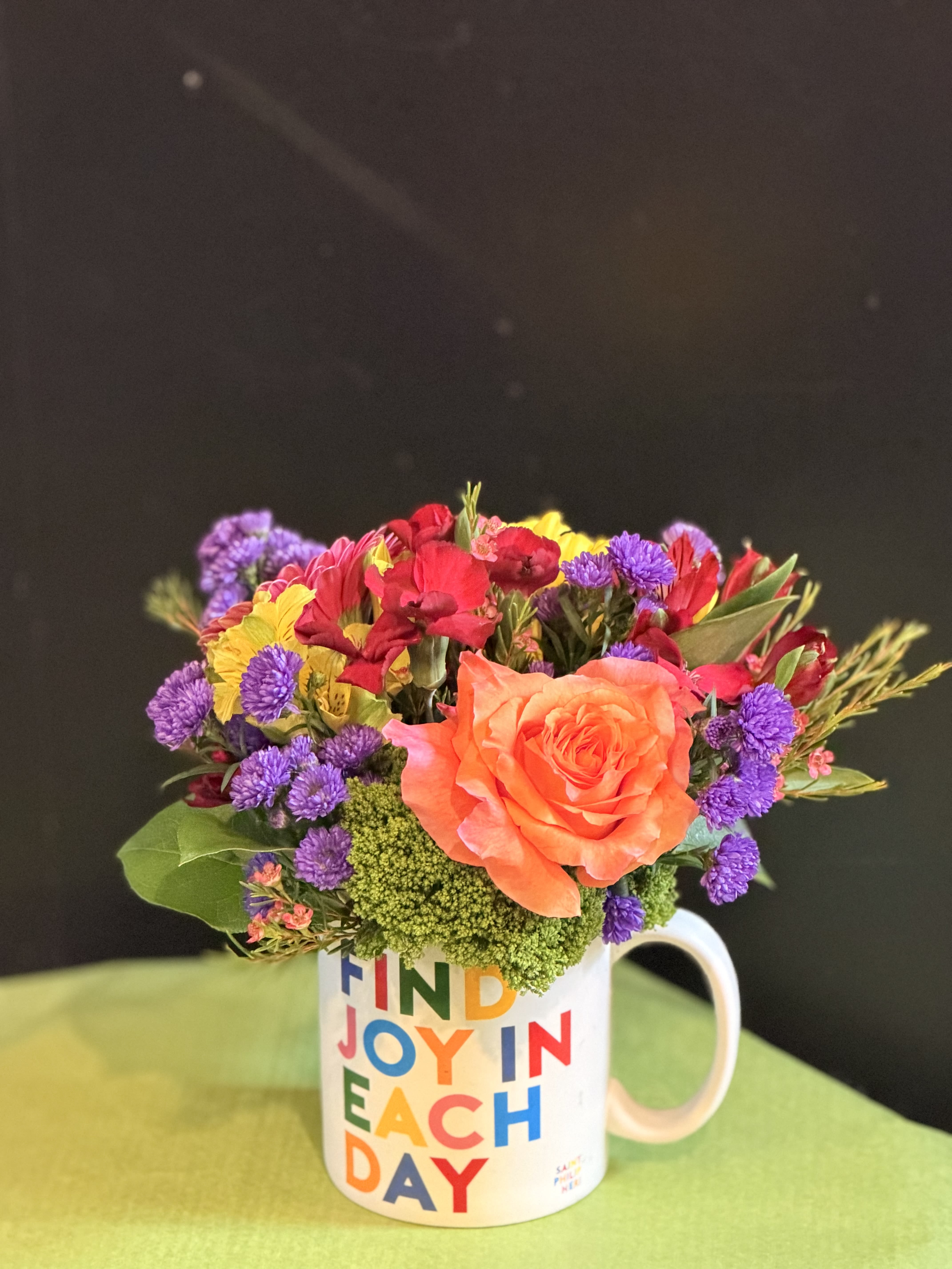 Find Joy in Each Day Mug - A cheerful floral arrangement featuring a vibrant mix of seasonal blooms, beautifully arranged in a colorful Quotable mug. The mug is microwave and dishwasher safe, making it a lasting keepsake to brighten each day