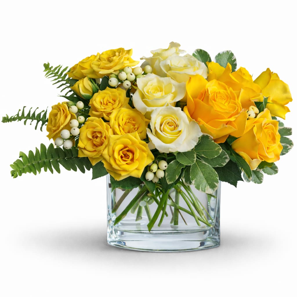 Yellow and white roses arranged in a clear glass vase