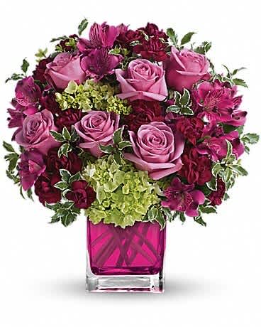 Pink and burgundy rose bouquet in a magenta glass vase