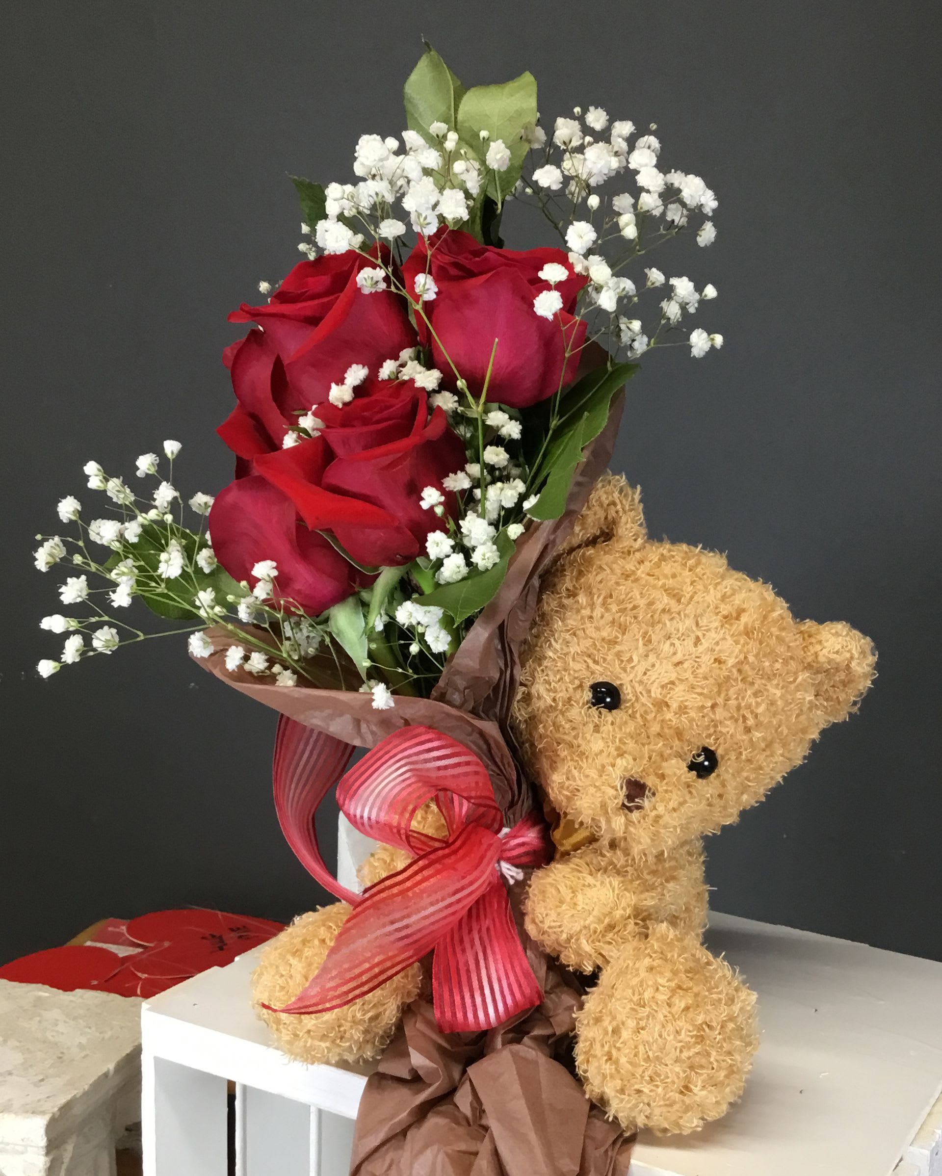 "Little Mitchy" - A medium Teddy Bear holding a Wrapped Bouquet of Roses, Filler and Greens