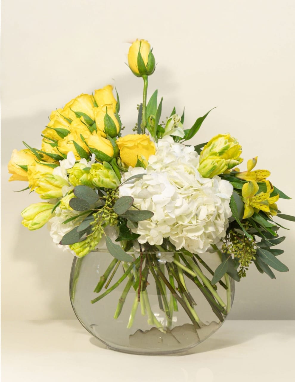 Ambiance - Warm, bright bursts of light and color radiate from this arrangement of blooms, creating an unforgettable ambiance and atmosphere. Bright yellow roses and tulips, along with pure white hydrangeas, will set the mood, and enchant and delight the senses. 