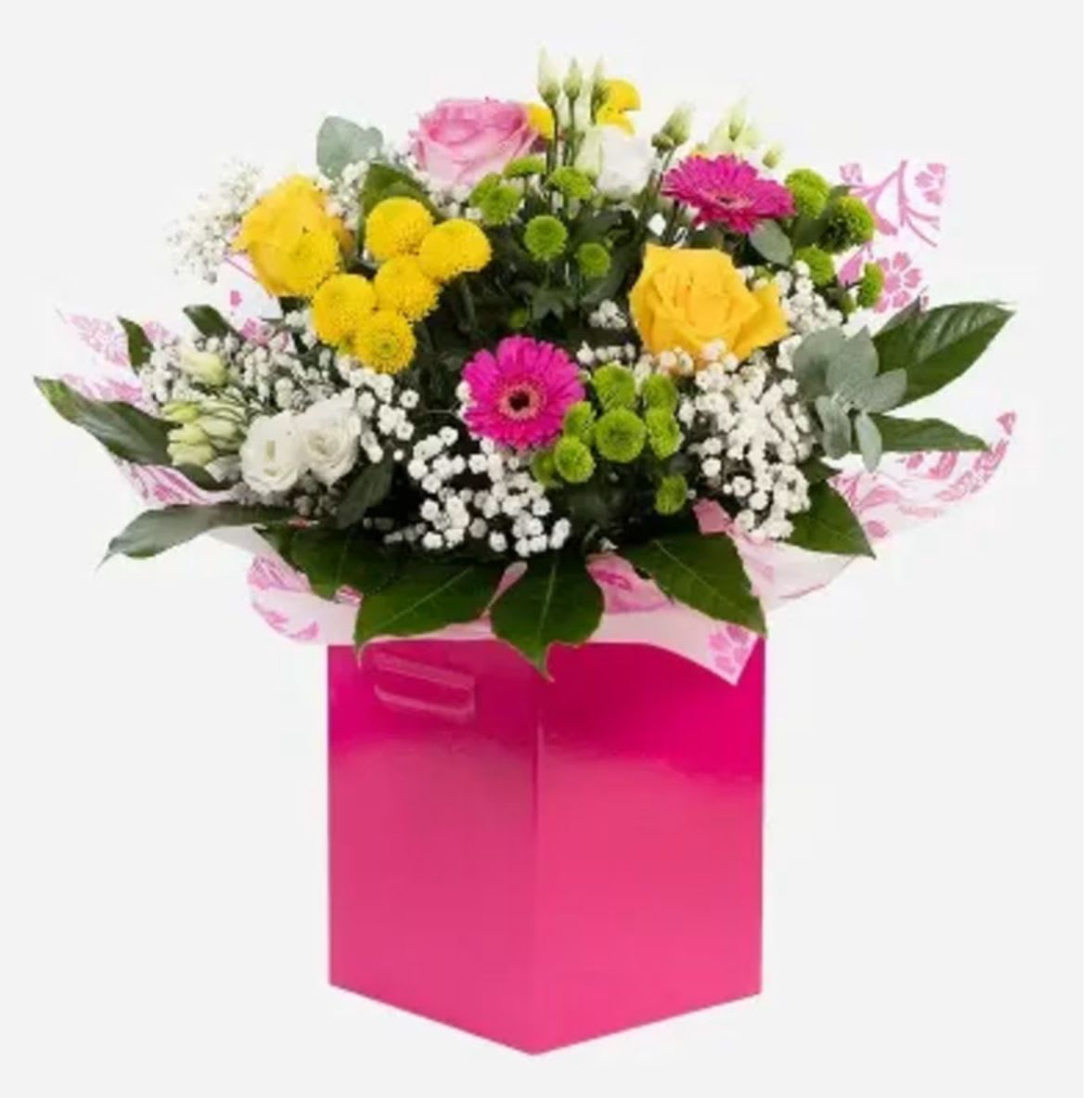 Mamma Mia - Brighten someone’s day with this stunning mixed flower bouquet in a pink gift box, featuring: • Yellow Roses – symbolizing joy and friendship • Hot Pink Gerbera Daisies – bold and cheerful blooms • Pink Roses – a timeless choice for love and gratitude • White Spray Roses – delicate and elegant mini roses • Chrysanthemums (Yellow &amp; Green Button Mums) – vibrant and long-lasting • White Gypsophila (Baby’s Breath) – soft filler flowers that add a romantic touch • Seasonal Greenery – lush foliage to complete the fresh look  Perfect for: birthdays, thank you gifts, celebrations, and everyday surprises.